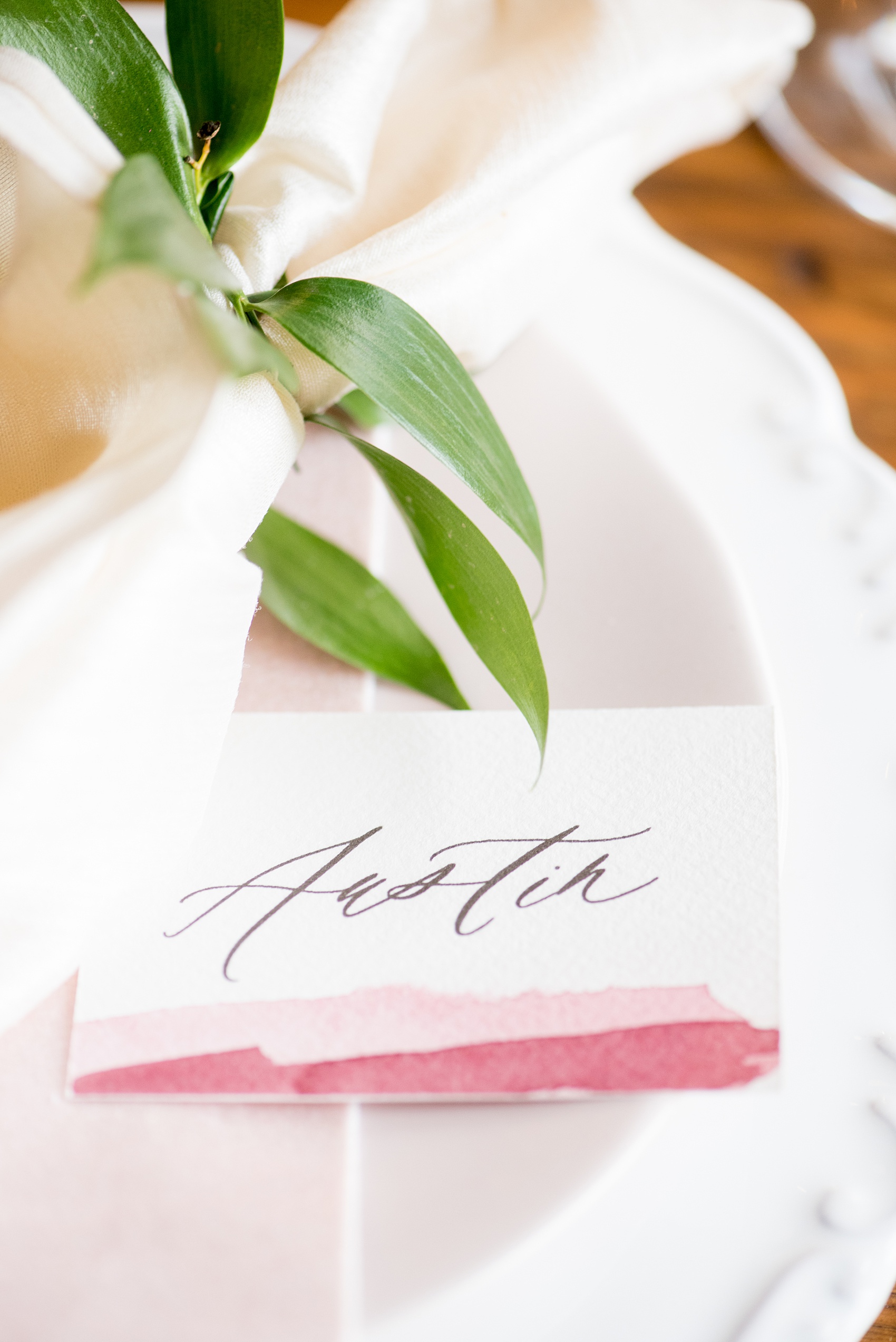 Photos from a wedding in downtown Raleigh, NC by Mikkel Paige Photography. The reception was held inside the historic venue, The Stockroom at 230. Guest place settings were topped with pale pink and white silk napkins and calligraphy watercolor name cards by One and Only.