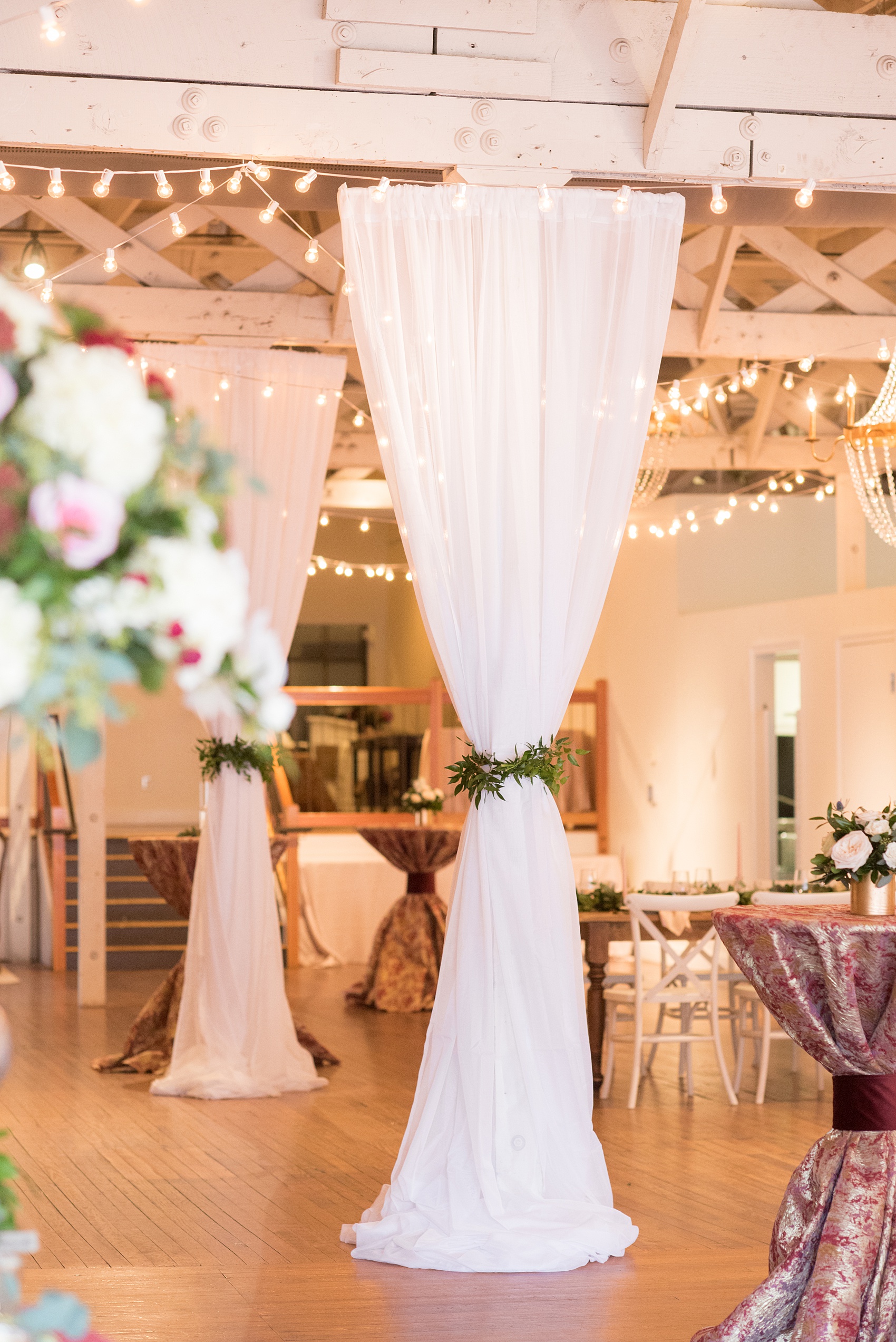 Photos from a wedding in downtown Raleigh, NC by Mikkel Paige Photography. The reception was held inside the historic venue, The Stockroom at 230. White linen drapery was hung around the venue and tied with greenery by Tre Bella.