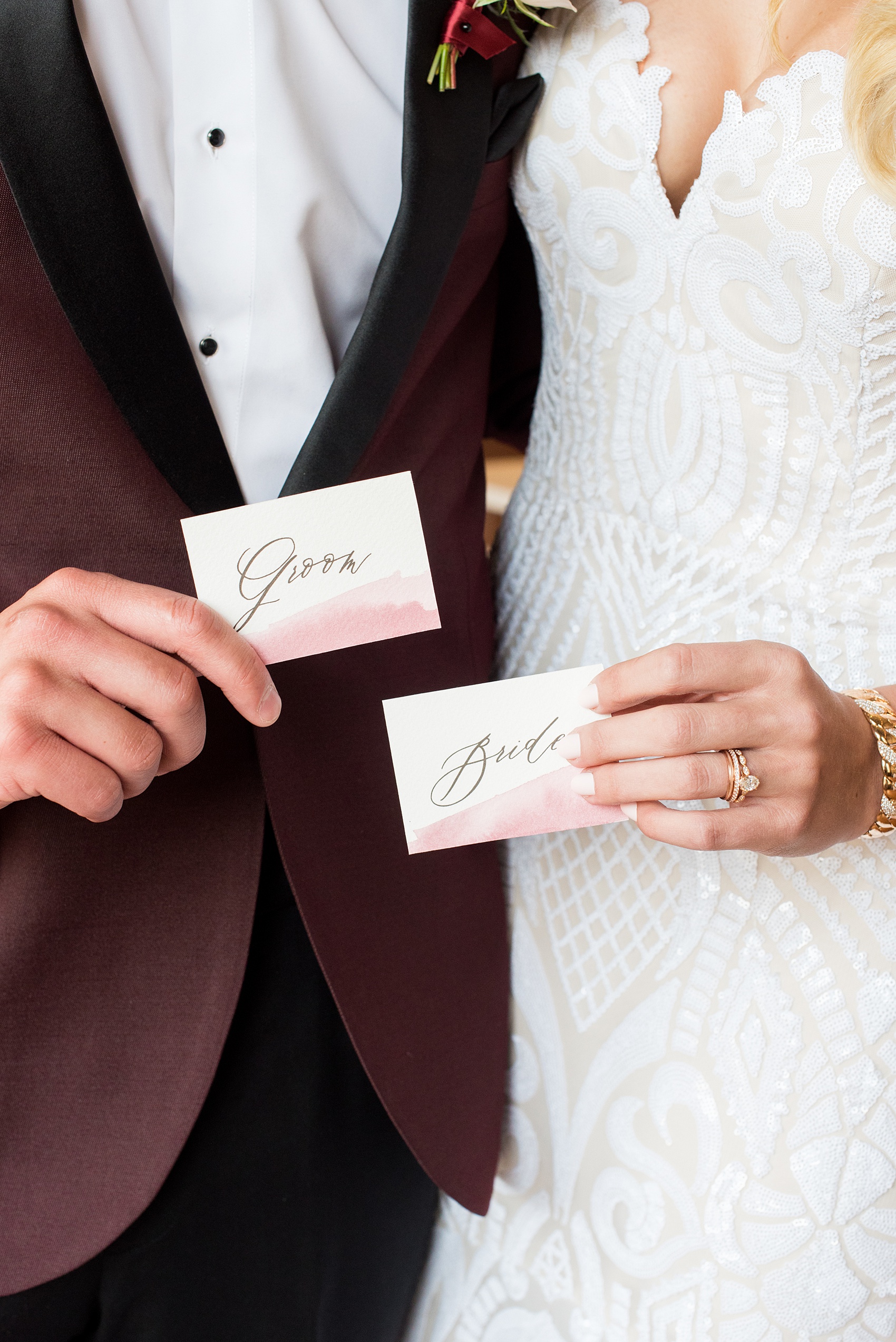 Photos from a wedding in downtown Raleigh, NC by Mikkel Paige Photography. The reception was held inside the historic venue, The Stockroom at 230. Guest place settings were topped with pale pink and burgundy calligraphy watercolor name cards by One and Only Paper. The bride and groom are pictured holding their custom cards!