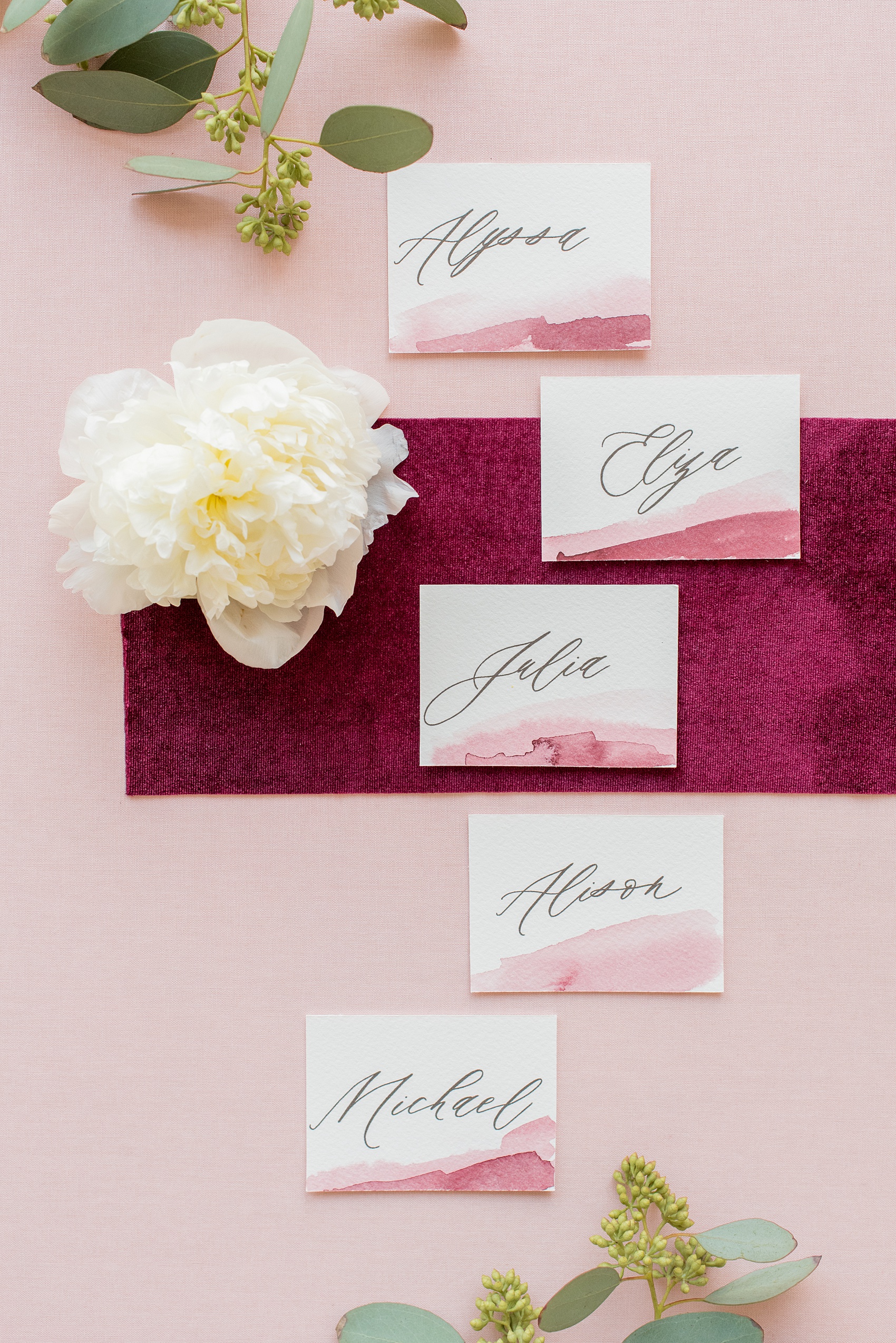 Photos from a wedding in downtown Raleigh, NC by Mikkel Paige Photography. The reception was held inside the historic venue, The Stockroom at 230. Guest place settings were topped with pale pink and burgundy calligraphy watercolor name cards by One and Only Paper.