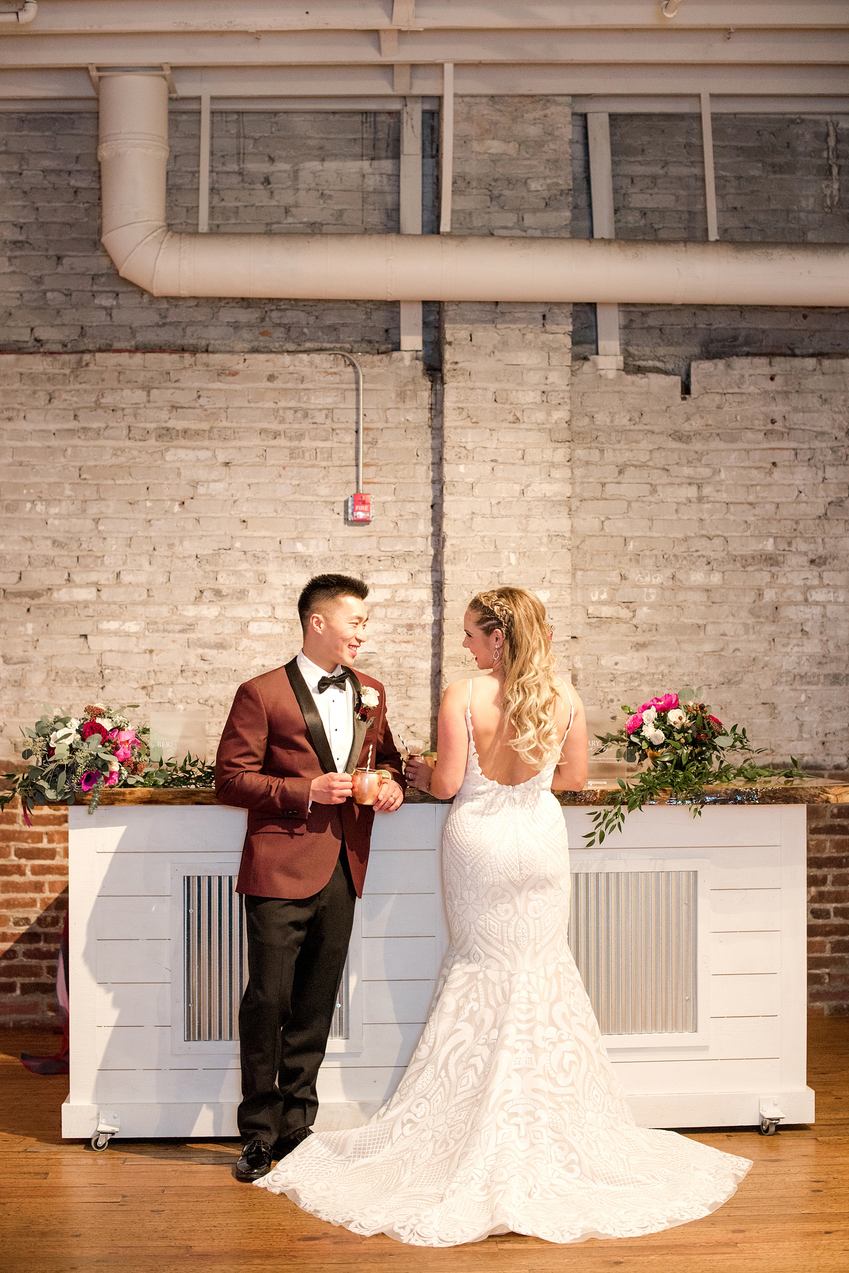 Photos from a wedding in downtown Raleigh, NC by Mikkel Paige Photography. The reception was held inside the historic venue, The Stockroom at 230. The bride and groom share a signature cocktail at the custom bar.