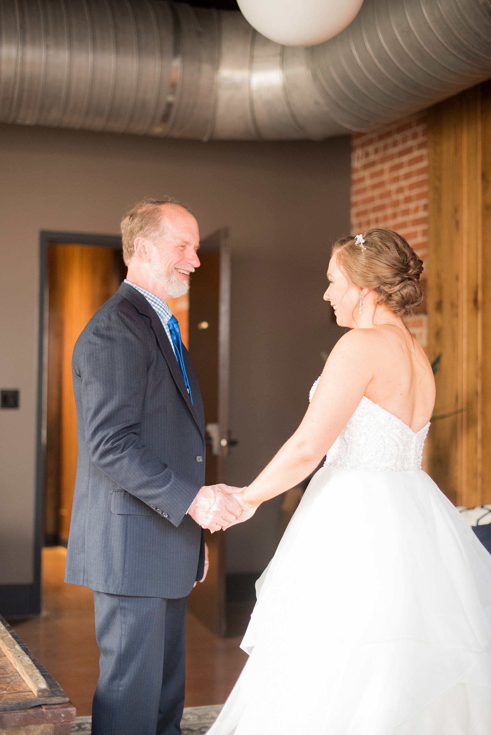 Durham wedding photos at The Cookery by Mikkel Paige Photography in North Carolina. The bride is pictured with her father, after a private special first look.