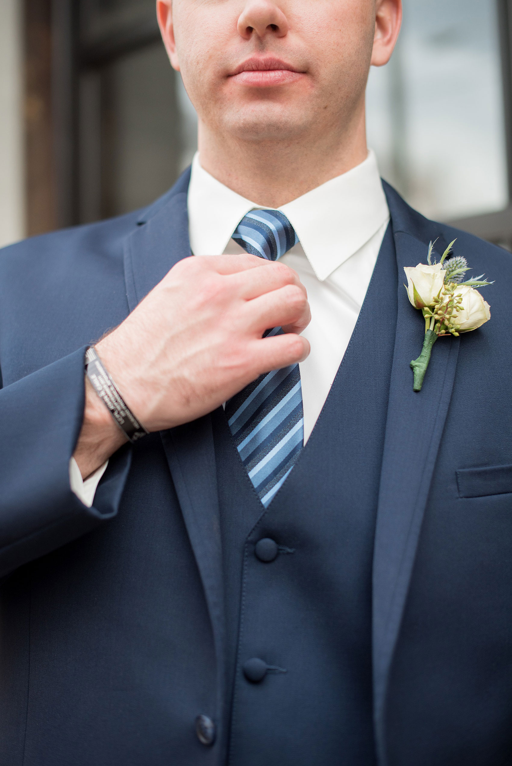 Durham wedding photos at The Cookery by Mikkel Paige Photography in North Carolina. The groom wore a navy double-breasted blue suit with a striped tie and white boutonniere.