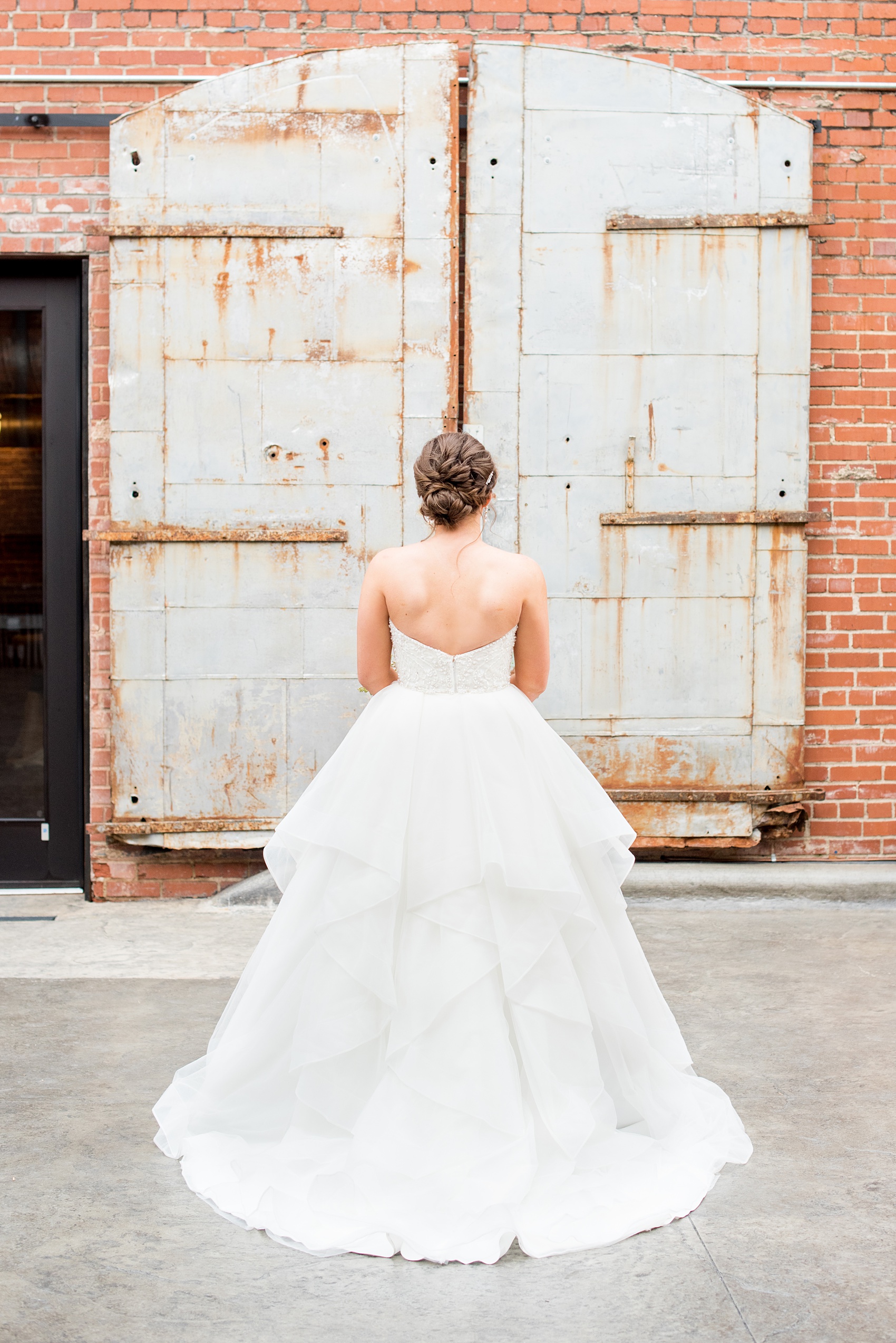 Durham wedding photos at The Cookery by Mikkel Paige Photography in North Carolina. The bride wore a strapless gown, had her hair in an up-do, and had many layers in her tulle skirt.