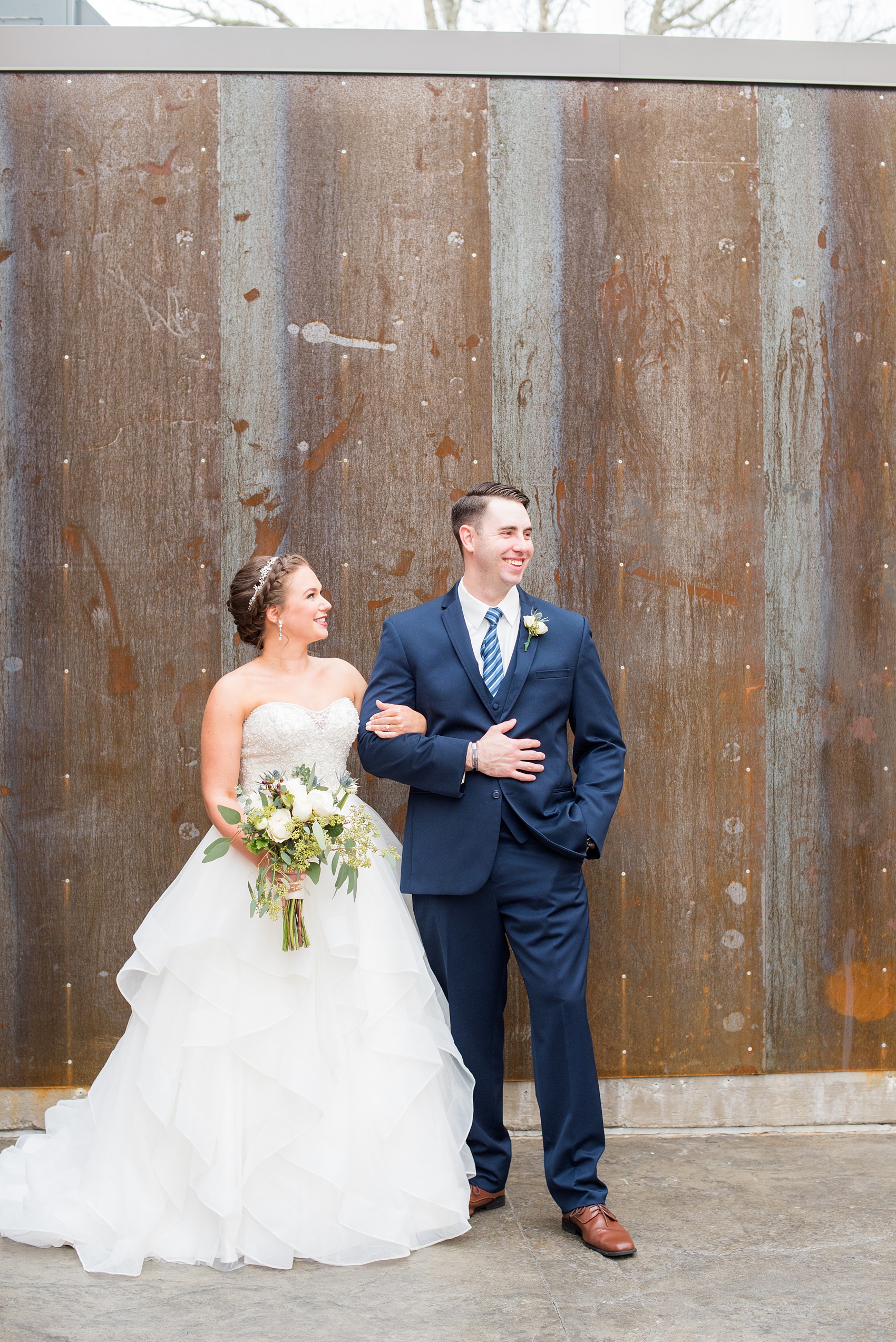 Durham wedding photos at The Cookery by Mikkel Paige Photography in North Carolina. The bride and groom did their first look by the venue's rustic, aged wall. 