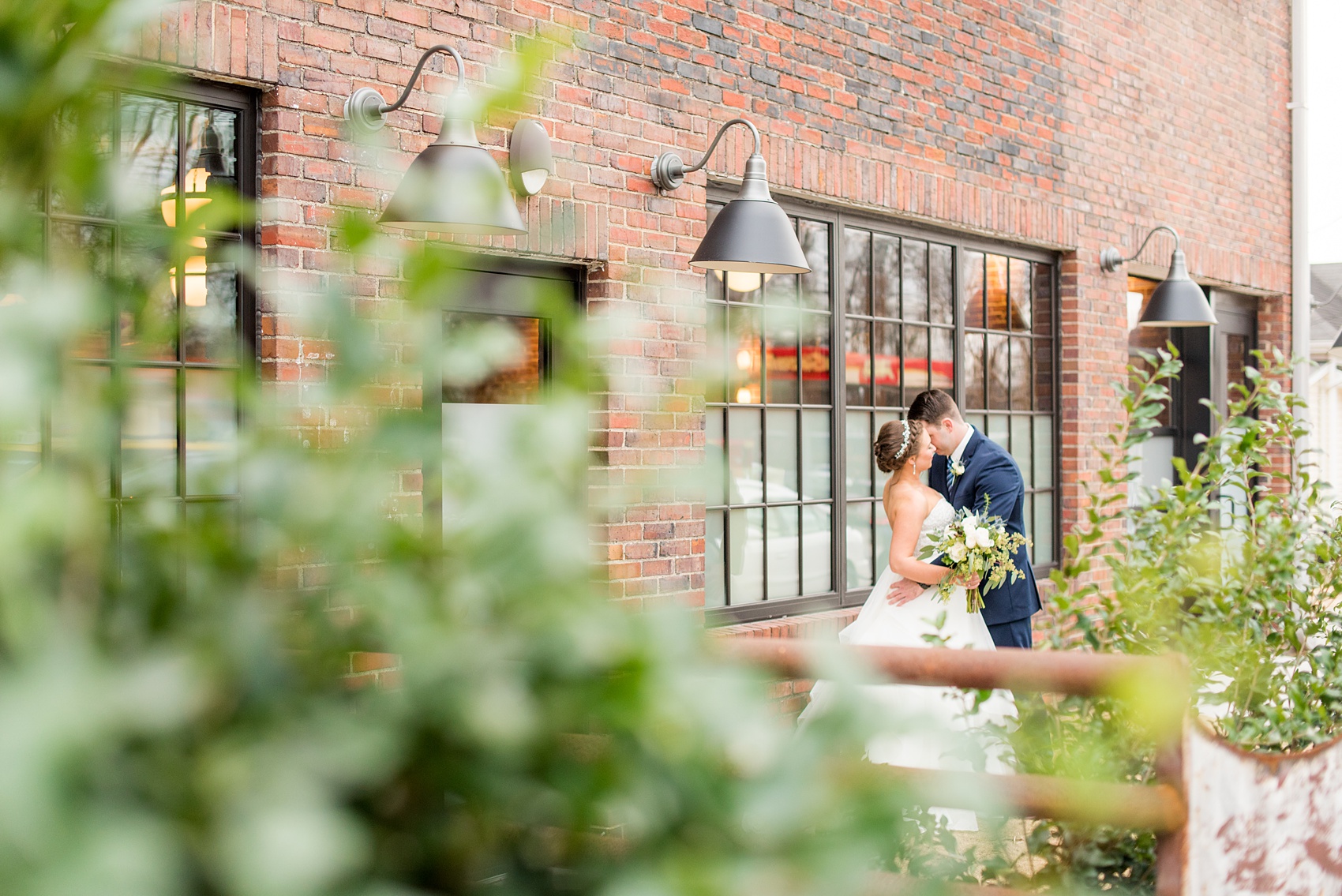 Durham wedding photos at The Cookery by Mikkel Paige Photography in North Carolina. The bride and groom stole a kiss in front of their brick, urban venue during their winter day.