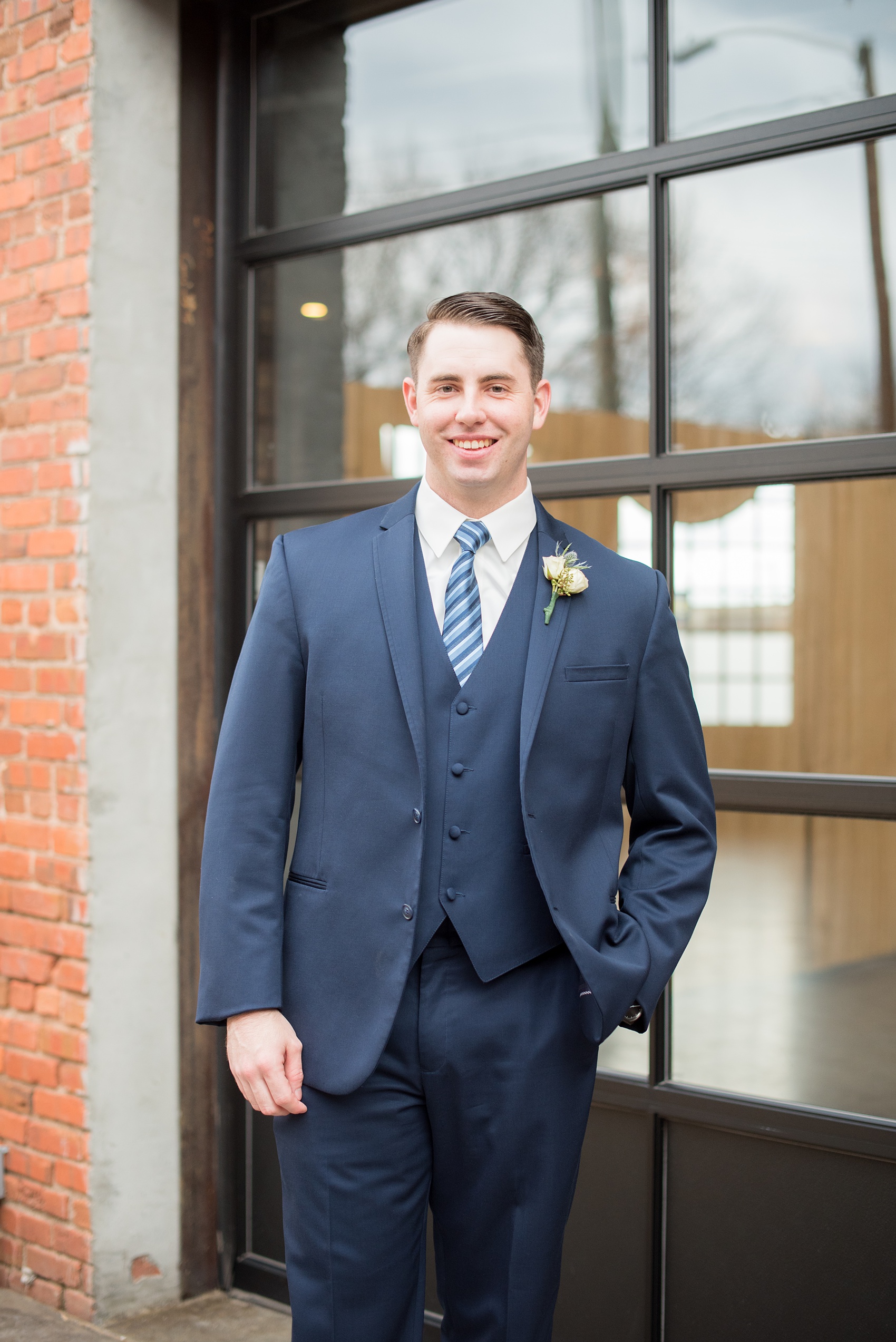 Durham wedding photos at The Cookery by Mikkel Paige Photography in North Carolina. The groom wore a navy double-breasted blue suit with a striped tie and white boutonniere.