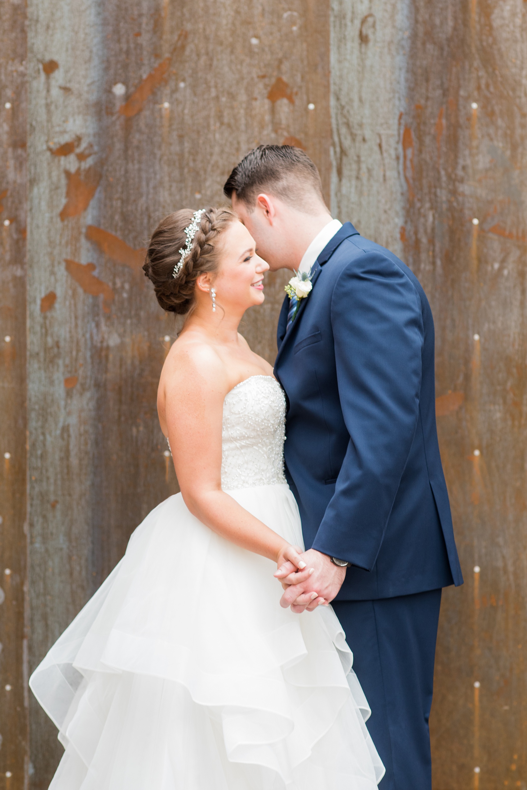 Durham wedding photos at The Cookery by Mikkel Paige Photography in North Carolina. The bride wore a strapless beaded gown with many layers in the skirt and groom wore a navy blue suit at their rustic winter day.