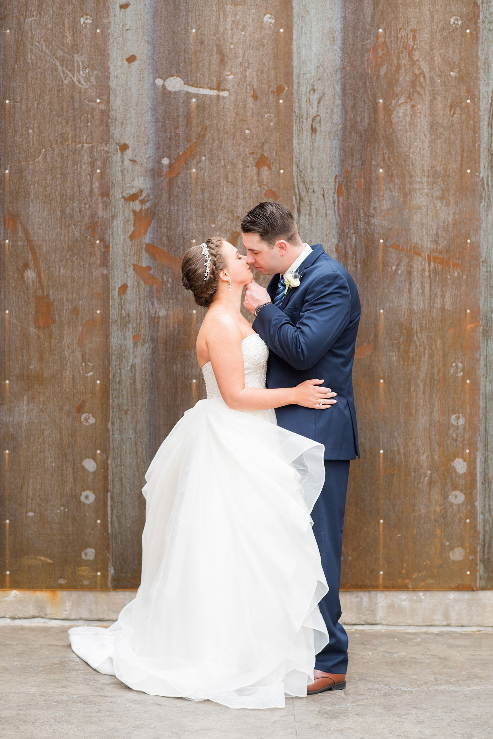 Durham wedding photos at The Cookery by Mikkel Paige Photography in North Carolina. The bride wore a strapless beaded gown with many layers in the skirt and groom wore a navy blue suit at their rustic winter day.