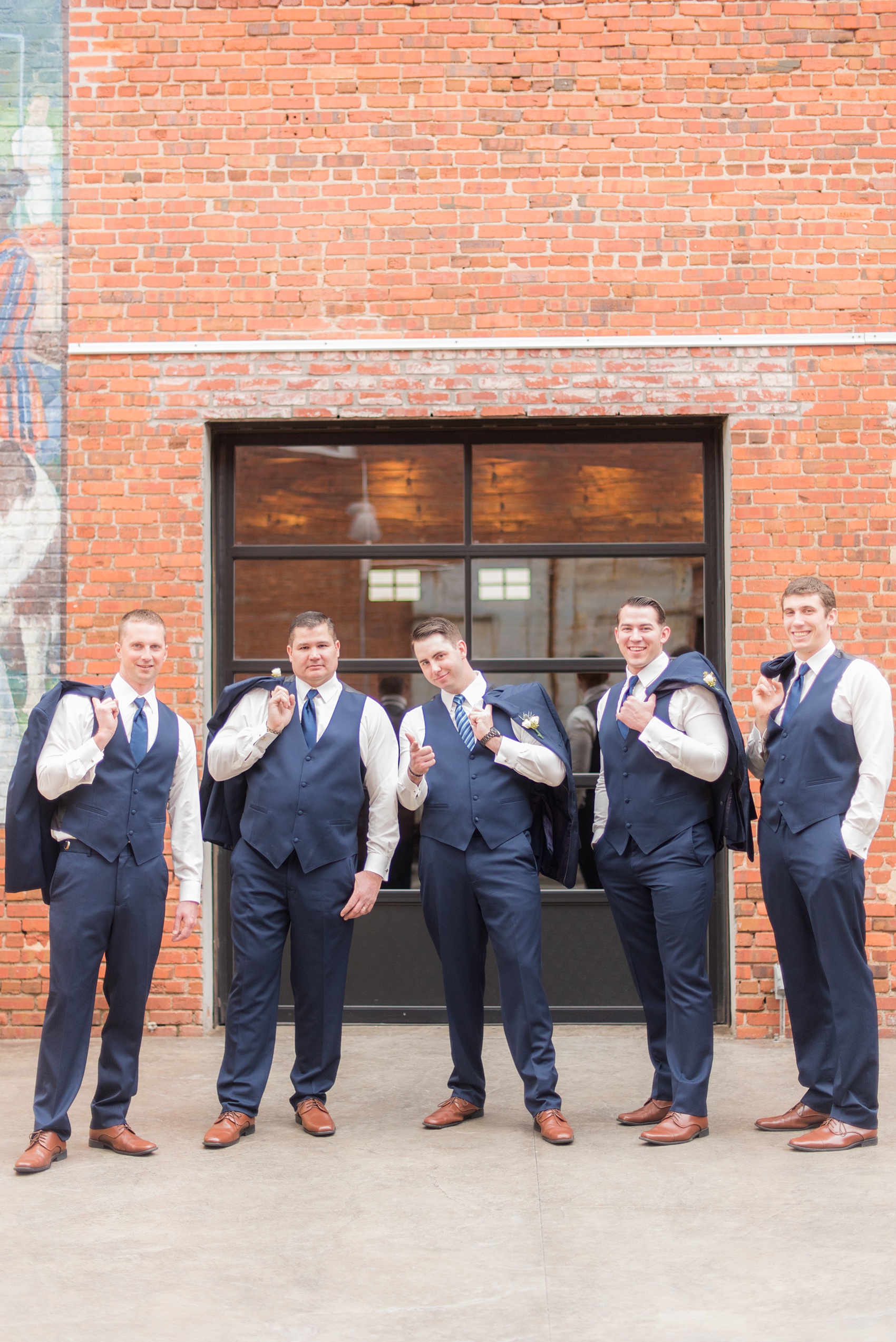 Durham wedding photos at The Cookery by Mikkel Paige Photography in North Carolina. The groomsmen wore navy blue suits with ties and brown shoes.