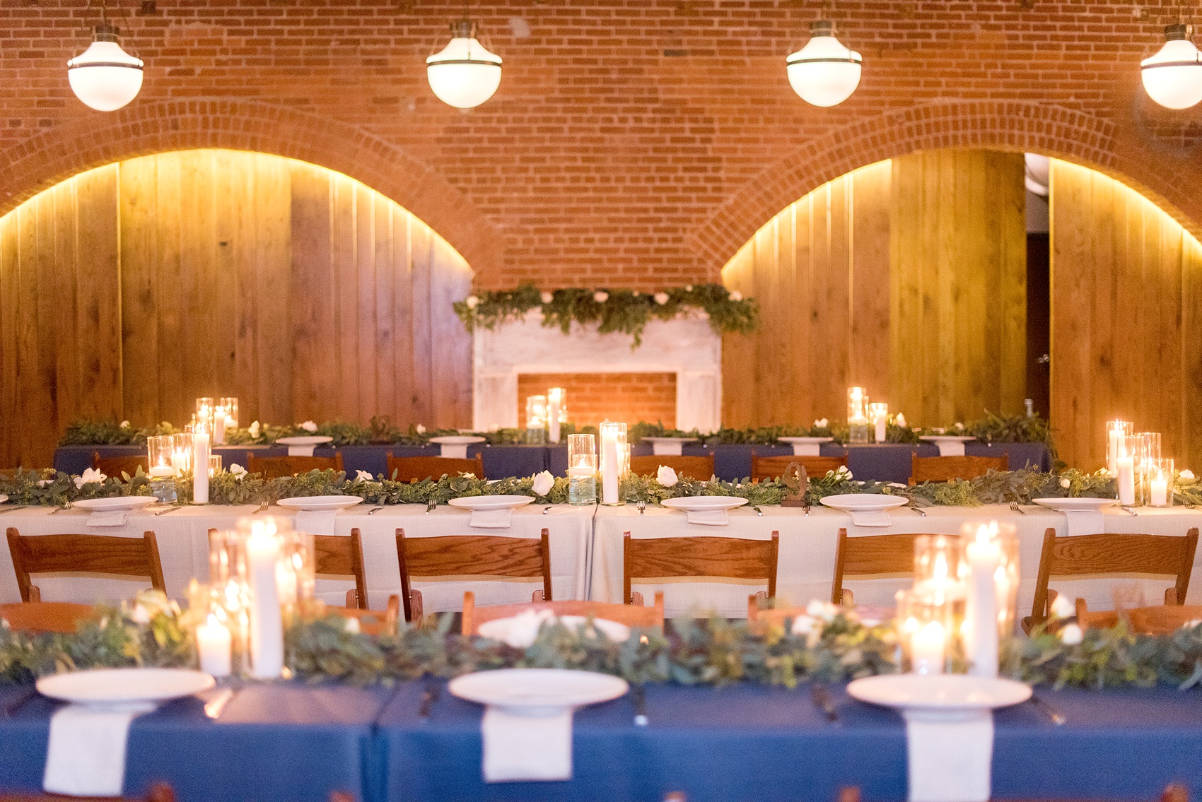 Durham wedding photos at The Cookery by Mikkel Paige Photography in North Carolina. The reception room had rectangular tables with garland greenery and candlelight illuminating the room.