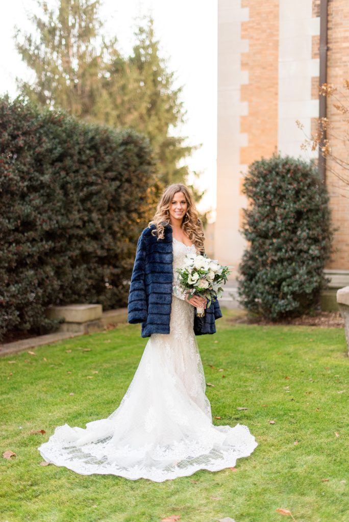 Wedding photos at Sleepy Hollow Country Club for a winter reception in January by Mikkel Paige Photography. The bride wore a long sleeve, lace gown with an open back and a blue faux fur coat for her winter wedding.