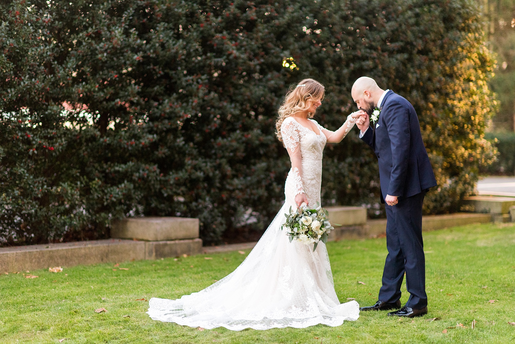 Wedding photos at Sleepy Hollow Country Club for a winter reception in January by Mikkel Paige Photography. The groom, in a navy blue tuxedo, kissed his bride's hand during their New York winter wedding.