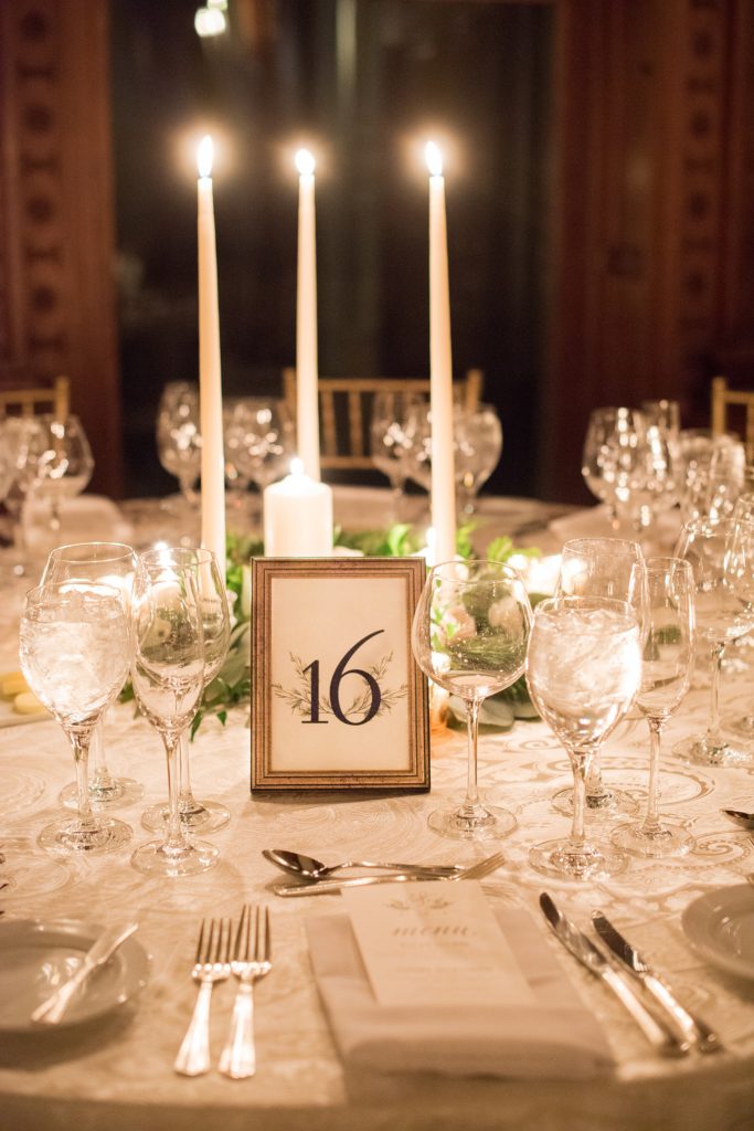 Wedding photos at Sleepy Hollow Country Club for a winter reception in January by Mikkel Paige Photography. Their New York winter wedding venue was decorated with a lot of candlelight and custom signage, including their table numbers.