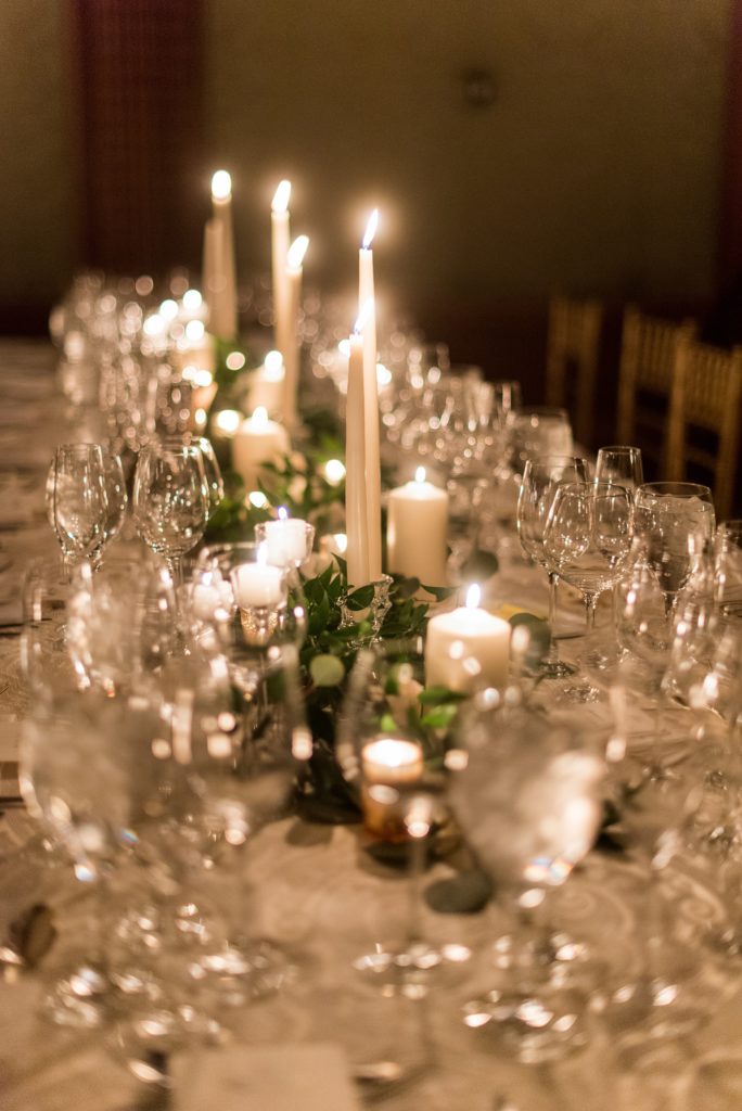 Wedding photos at Sleepy Hollow Country Club for a winter reception in January by Mikkel Paige Photography. Their New York winter wedding venue was drenched in greenery and warm candlelight.