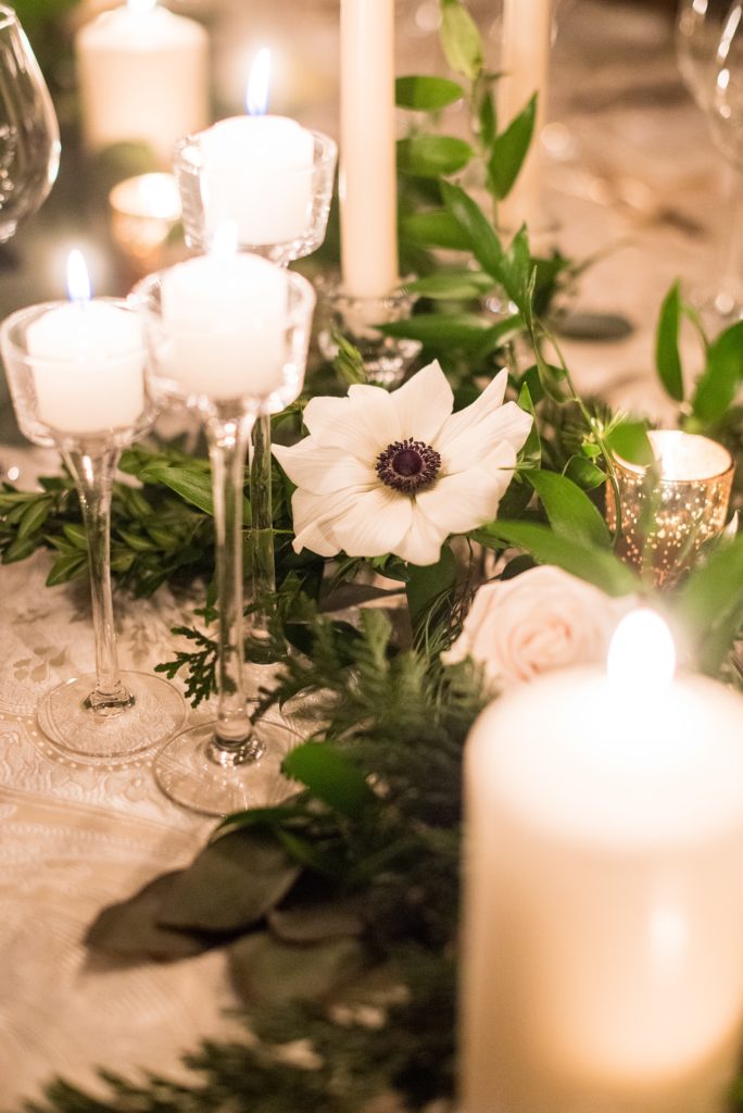 Wedding photos at Sleepy Hollow Country Club for a winter reception in January by Mikkel Paige Photography. Their New York winter wedding venue was drenched in greenery and warm candlelight.