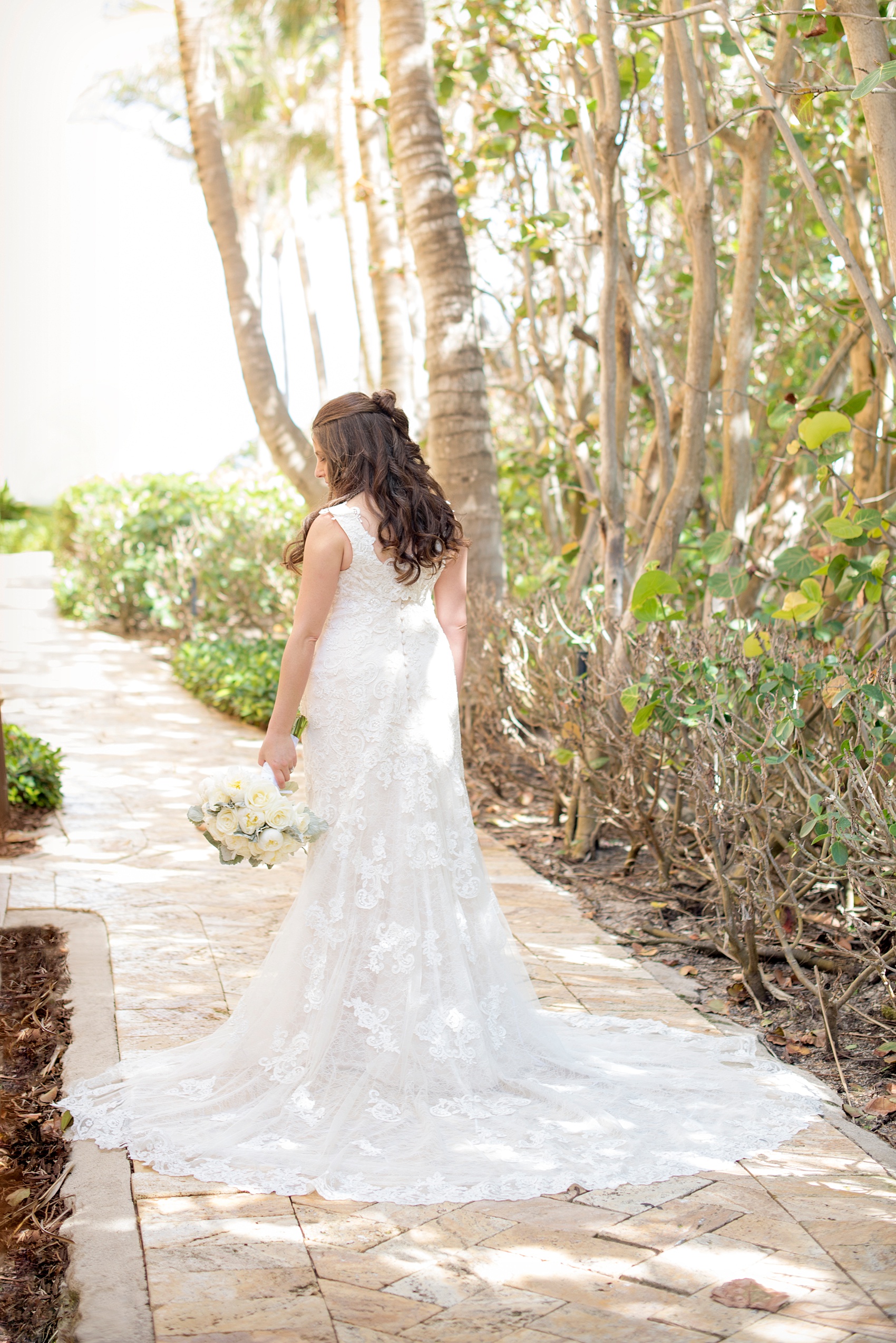 Wedding photos at Eau Palm Beach by Mikkel Paige Photography. Pictures right next to the ocean for a destination wedding. The bride wore a simple lace gown with a beautiful train. 