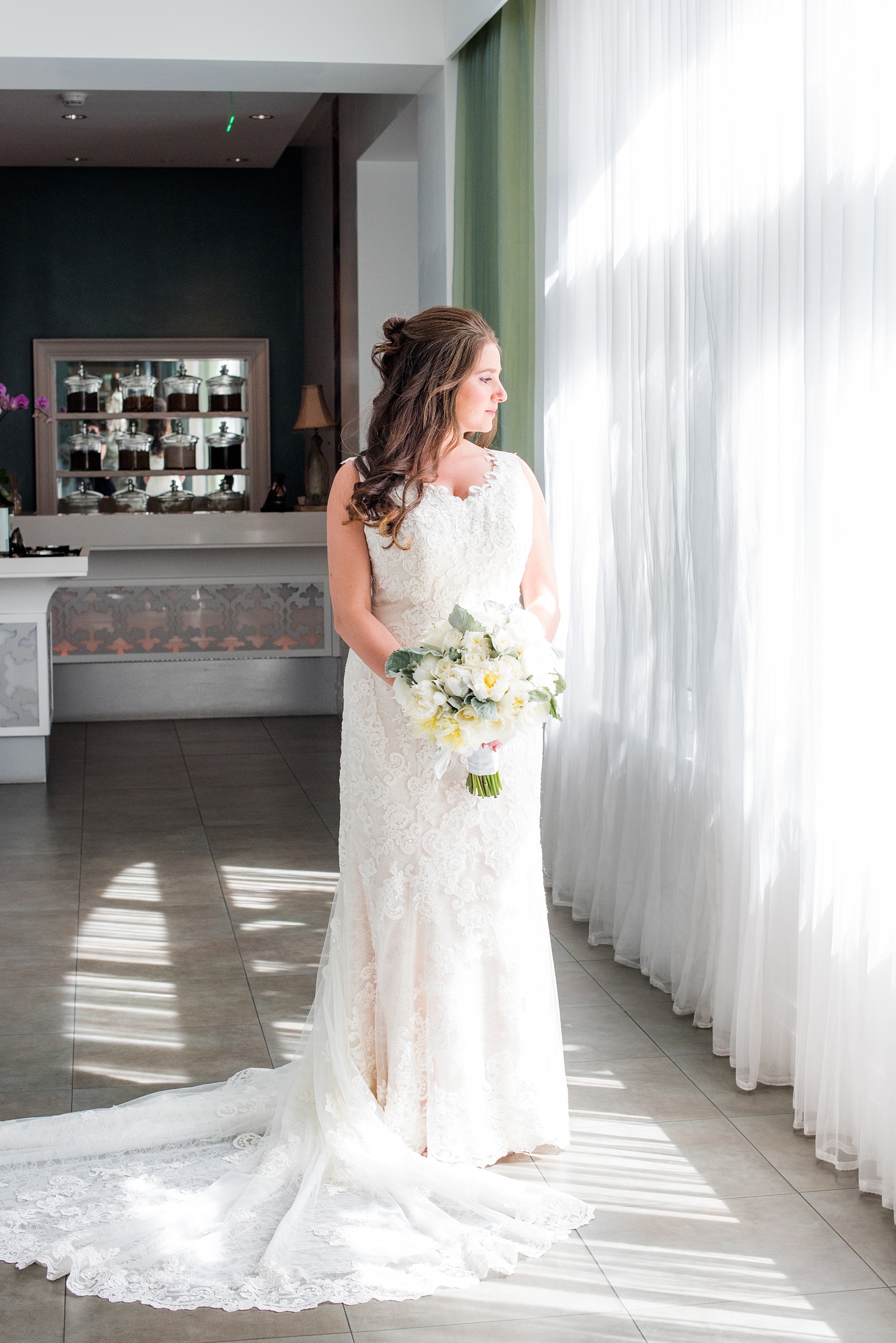 Eau Palm Beach wedding photos by Mikkel Paige Photography. This luxury Florida resort is a beautiful location for a destination wedding! In this picture, the bride reflects on the day before seeing her groom, in her lace gown holding her white peony bouquet. Click through for more! #WestPalmBeach #EauPalmBeach #BeachWedding #FloridaWeddings #BeachBride