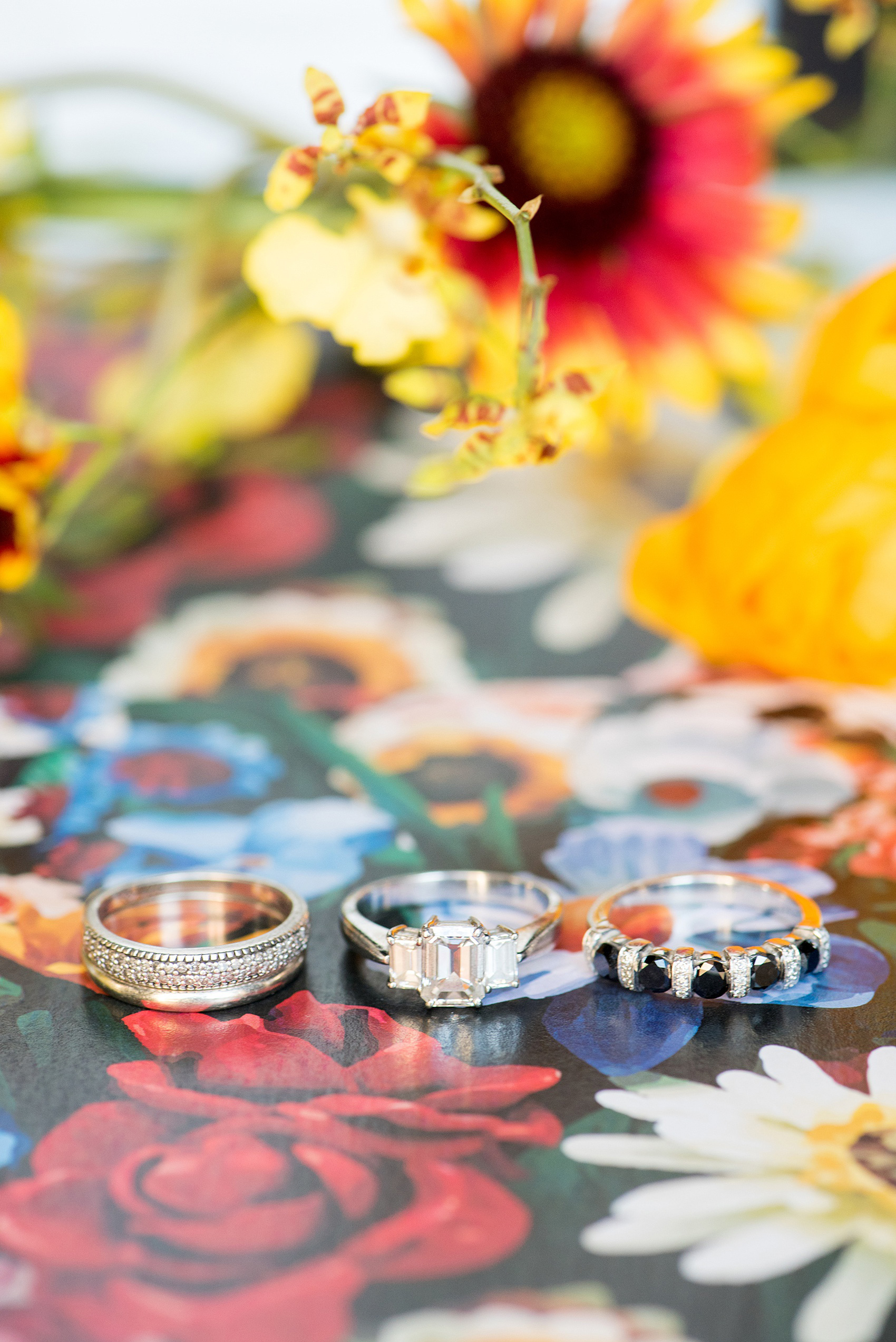 Mikkel Paige Photography photos of a wedding at the Green Building in Brooklyn, New York. This same sex, gay marriage styled shoot was created by Color Pop Events. This detail picture shows the bride's ring was black and white diamonds with an emerald cut engagement ring. Flowers by Abby Tabak Studio.