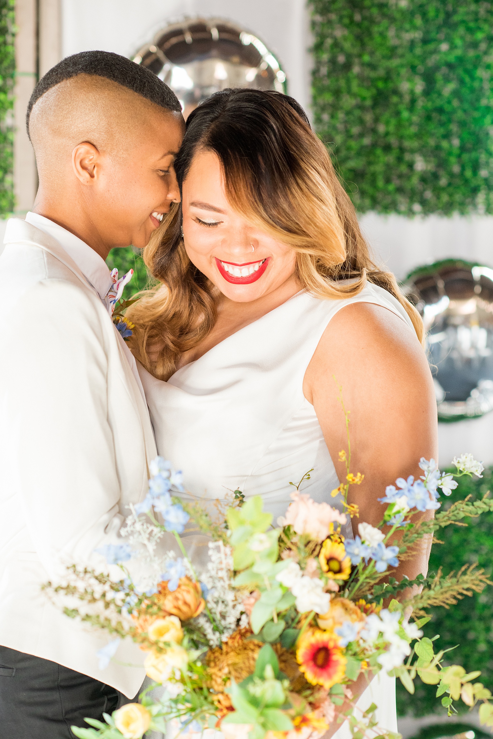 Mikkel Paige Photography photos of a wedding at the Green Building in Brooklyn, New York. This same sex, gay marriage styled shoot was created by Color Pop Events. They recited vows during their ceremony in front of silver mylar balloons and green square boxwood patches.