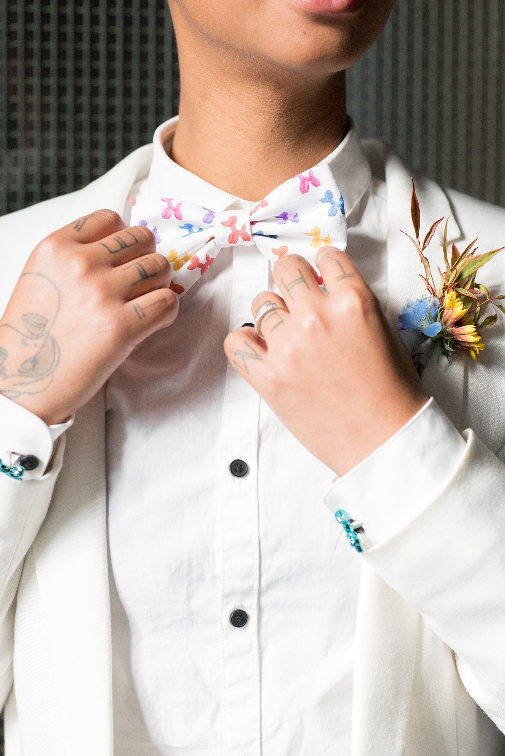 Mikkel Paige Photography photos of a wedding at the Green Building in Brooklyn, New York. This same sex, gay marriage styled shoot was created by Color Pop Events. The model wore a white jacket and white shirt with black buttons and Jeff Koons blue balloon animal cufflinks. They wore a balloon animal bow tie to match.