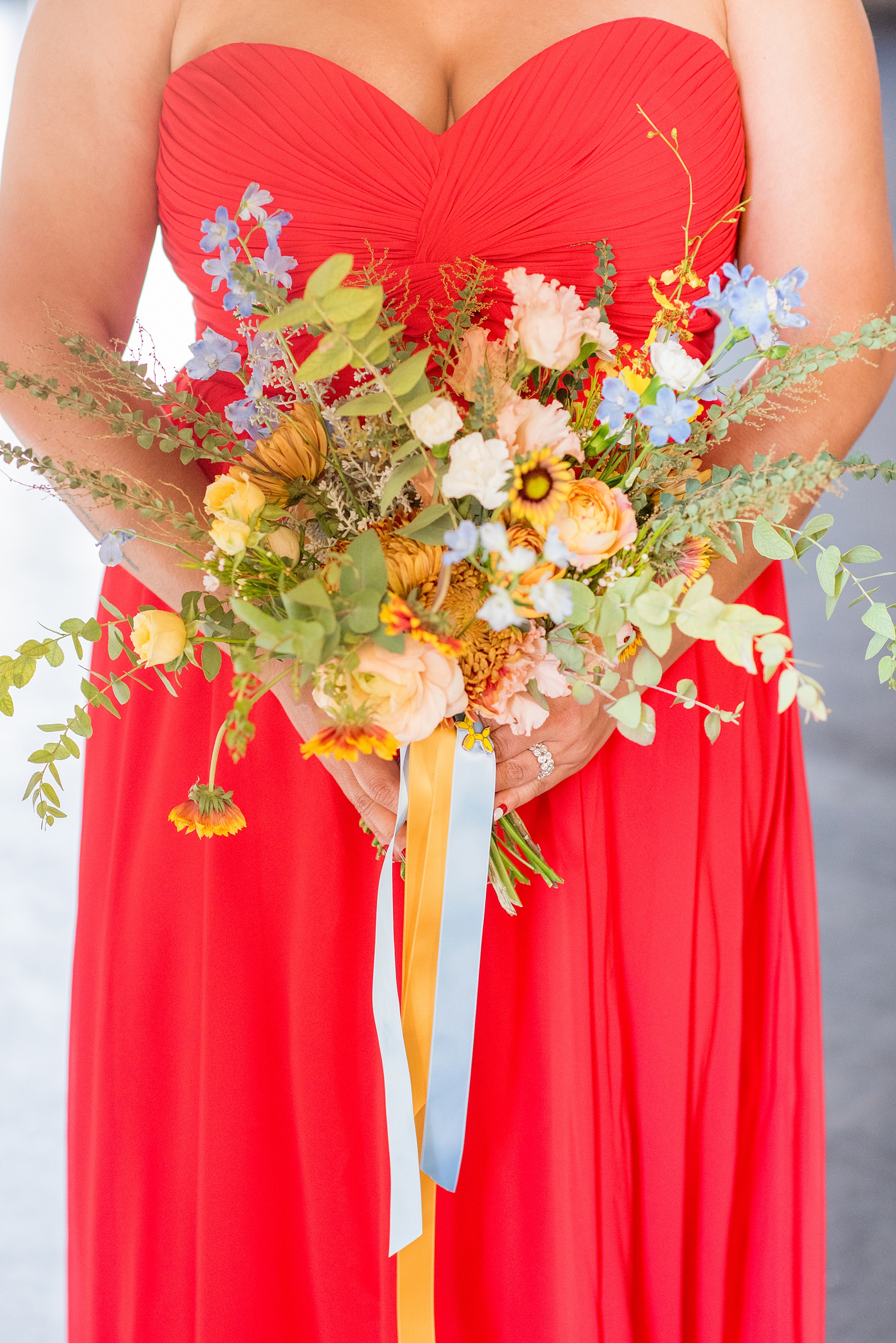 Mikkel Paige Photography photos of a wedding at the Green Building in Brooklyn, New York. This same sex, gay marriage styled shoot was created by Color Pop Events. This picture of the fall inspired bouquet shows it includes orange, yellow and blues, with garden roses, chrysanthemum, orchids and eucalyptus by Abby Tabak Studio.