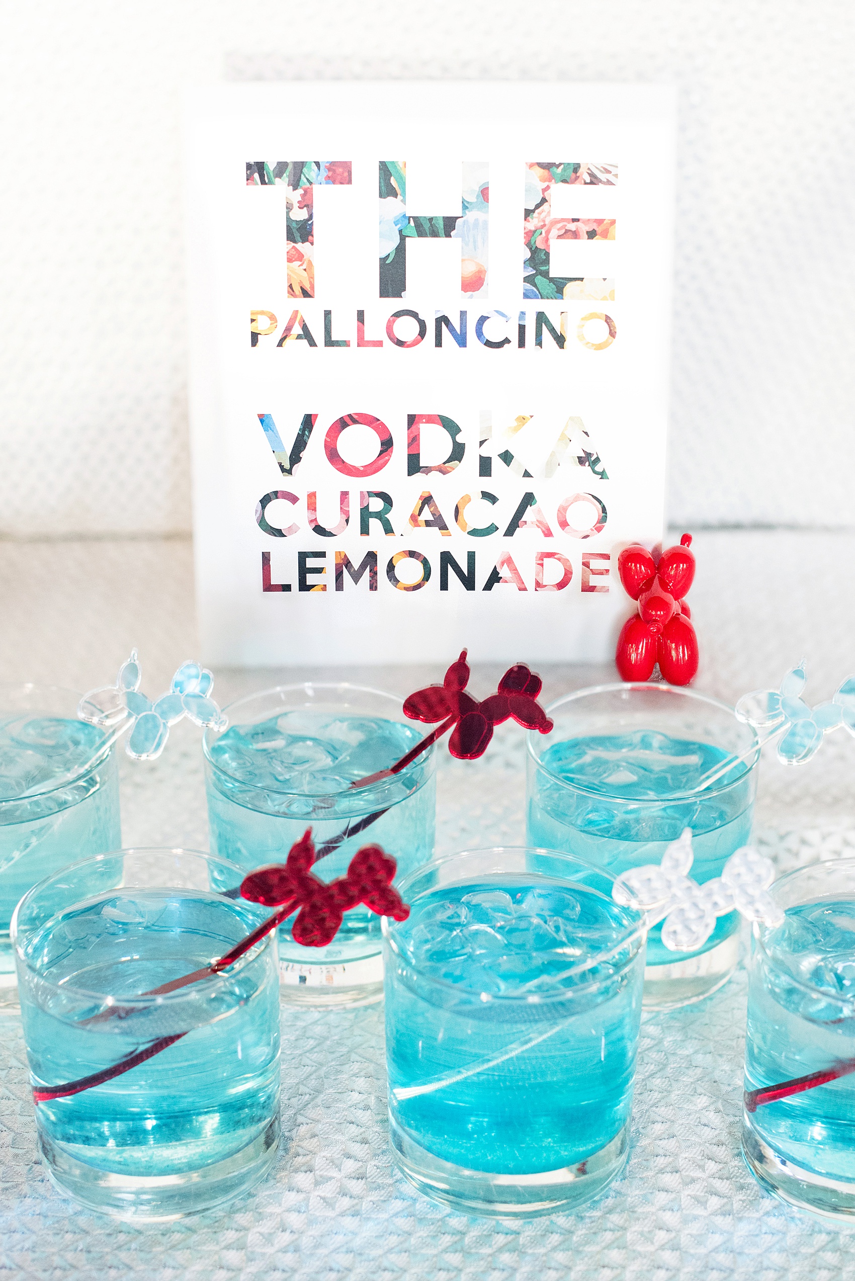 Mikkel Paige Photography images of a wedding at the Green Building in Brooklyn, New York. This same sex, gay marriage styled shoot was created by Color Pop Events. The acrylic custom drink stirrers were in red, yellow, blue and silver and said "Love Is Love" by California Lustre. Custom Vodka Curacao Lemonade signature cocktails by Ryan Brown Catering.