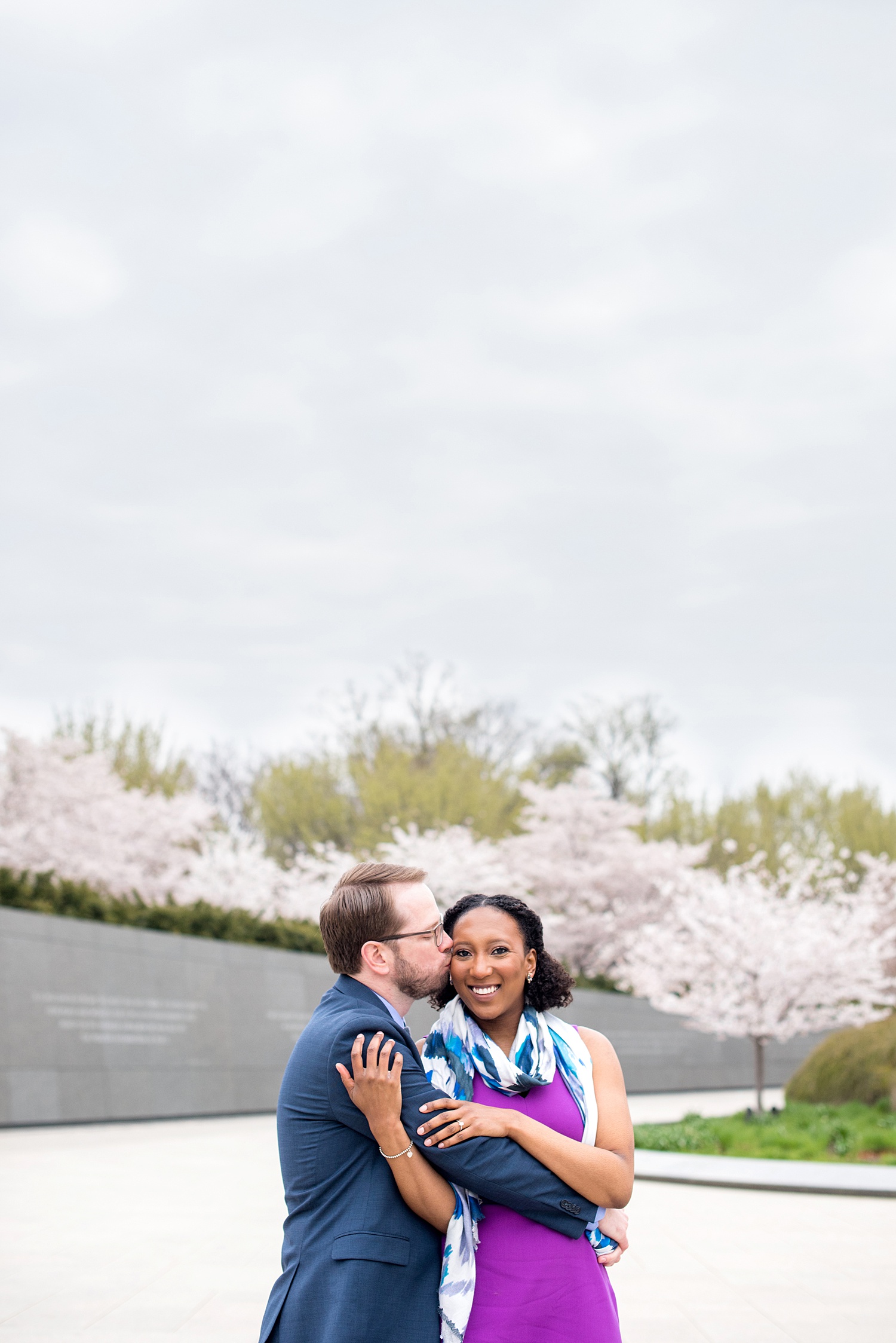 DC Cherry Blossoms Engagement Photos by Mikkel Paige Photography. Spring flowers around the MLK memorial and Tidal Basin at the nation's Capitol with an interracial couple. #DCCherryBlossoms #CherryBlossoms #EngagementPhotos #SpringEngagementPhotos #CherryBlossomsEngagementPhotos