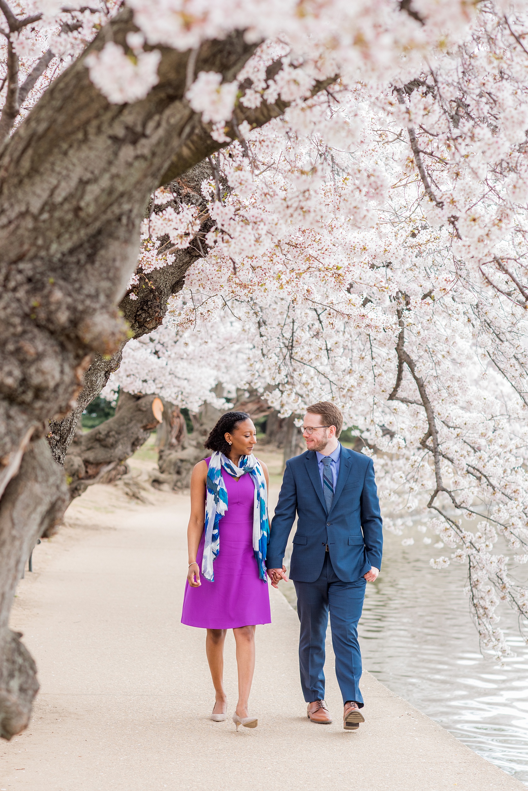 DC Cherry Blossoms Engagement Photos by Mikkel Paige Photography. Spring flowers around the MLK memorial and Tidal Basin at the nation's Capitol with an interracial couple. #DCCherryBlossoms #CherryBlossoms #EngagementPhotos #SpringEngagementPhotos #CherryBlossomsEngagementPhotos