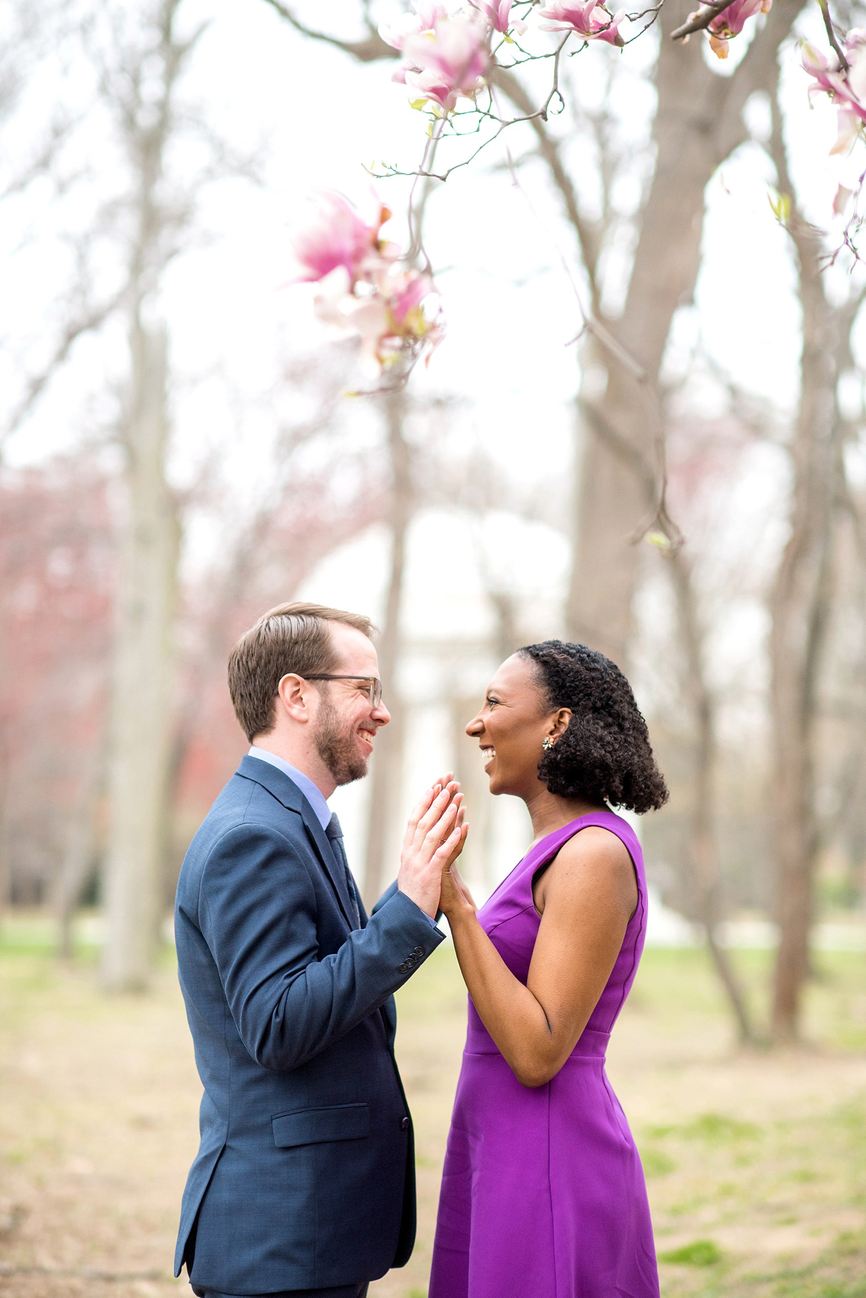 DC Cherry Blossoms Engagement Photos by Mikkel Paige Photography. Spring flowers around the MLK memorial and Tidal Basin at the nation's Capitol with an interracial couple in colorful outfits. #DCCherryBlossoms #CherryBlossoms #EngagementPhotos #SpringEngagementPhotos #CherryBlossomsEngagementPhotos