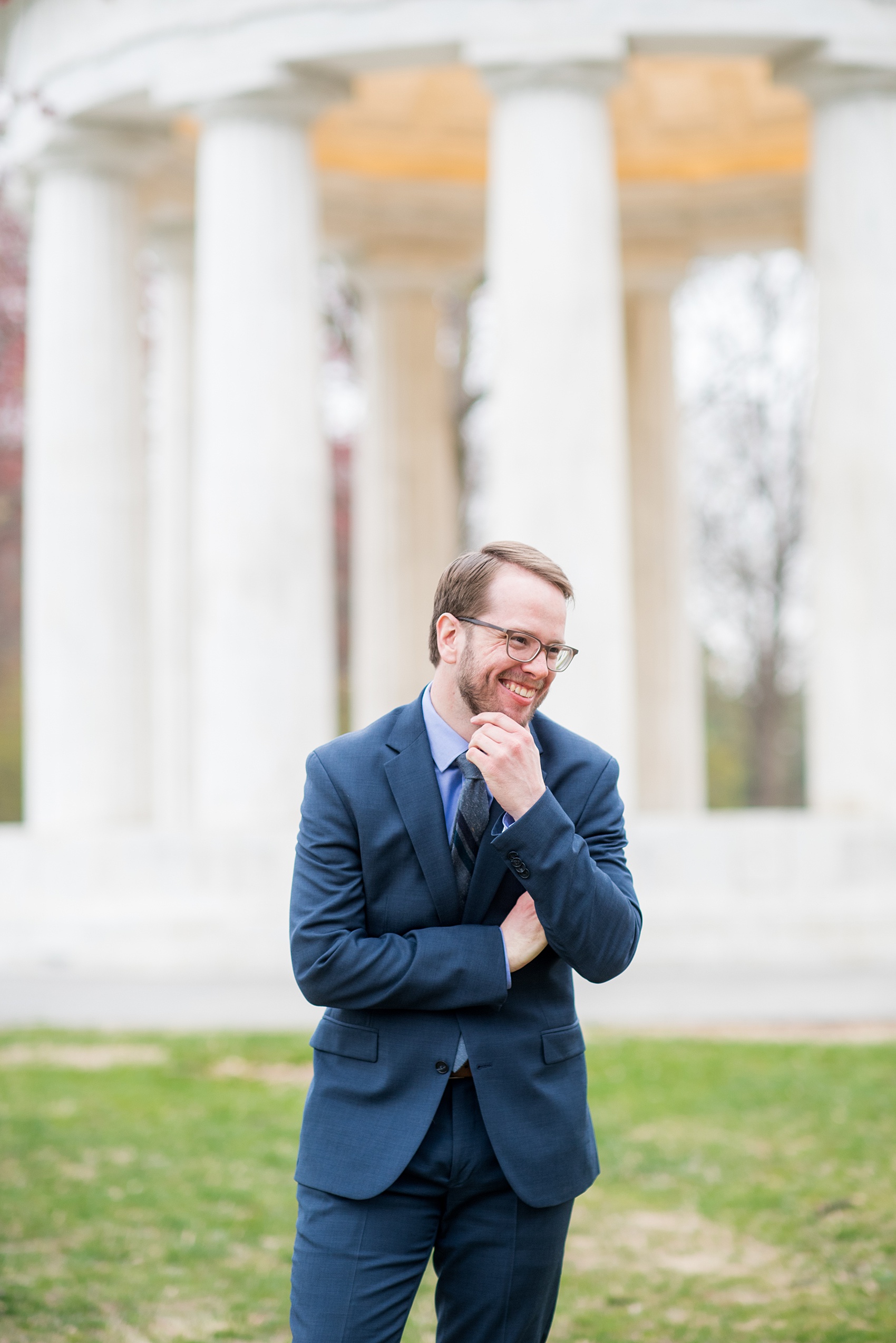 DC Cherry Blossoms Engagement Photos by Mikkel Paige Photography. Spring flowers around the MLK memorial and Tidal Basin at the nation's Capitol with a Caucasian groom in a navy blue linen suit. #DCCherryBlossoms #CherryBlossoms #EngagementPhotos #SpringEngagementPhotos #CherryBlossomsEngagementPhotos