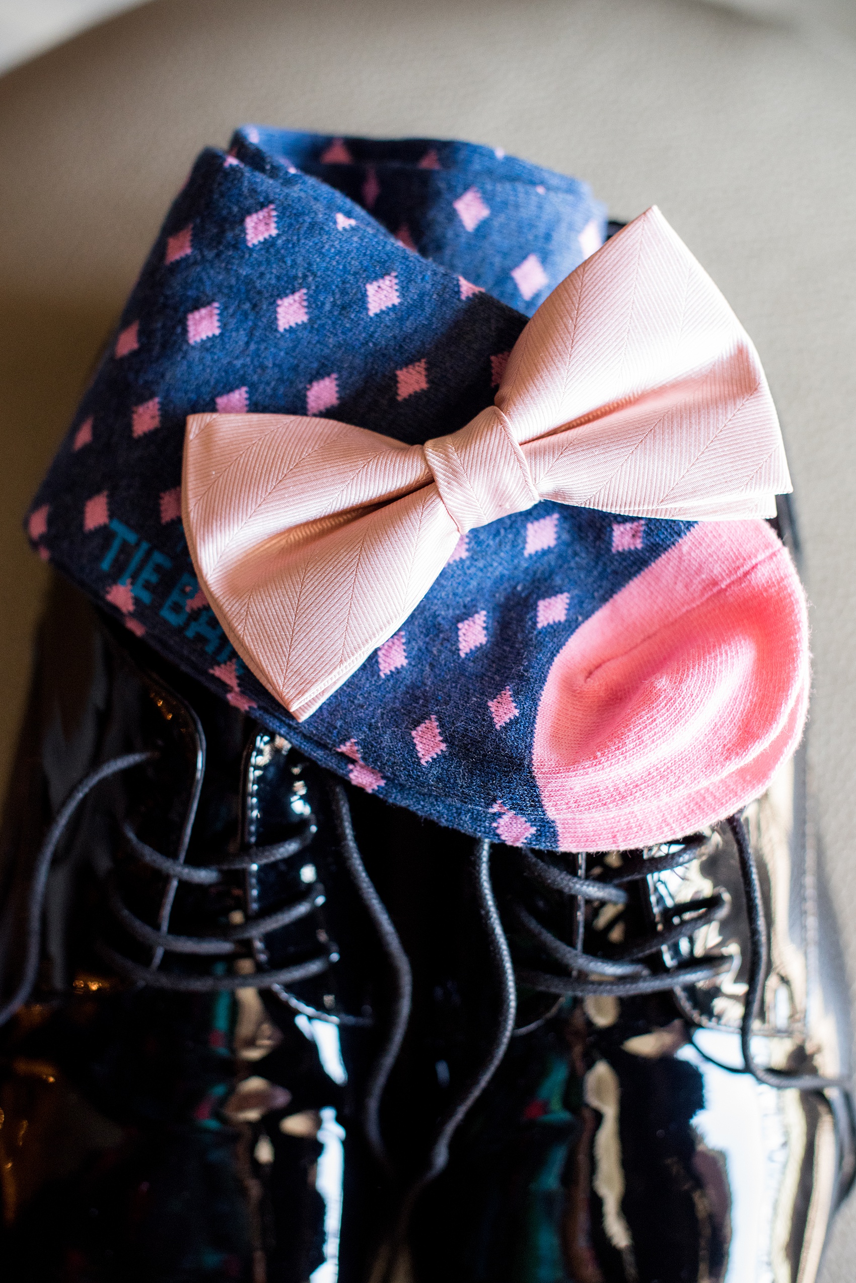 Saratoga Springs destination wedding photos by Mikkel Paige Photography. The groom prepared for his day with details like navy and pink socks, and a blush bow tie at the Pavilion Grand hotel downtown. #SaratogaSpringsNY #SaratogaSprings #mikkelpaige #NYwedding #destinationwedding 