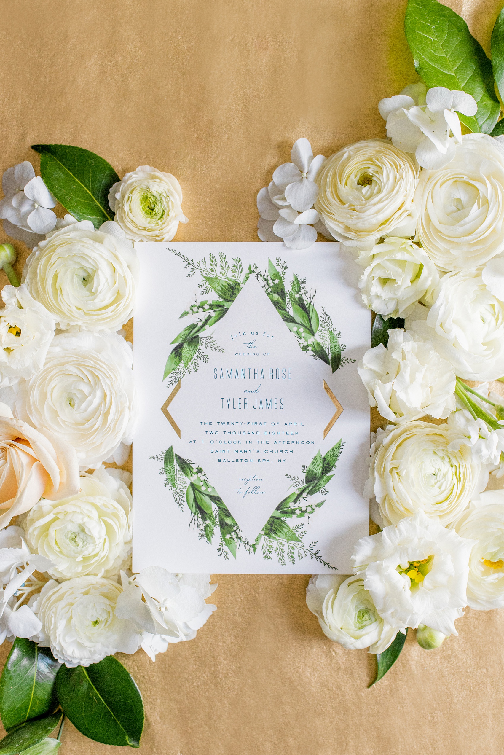 Photo of a green invitation in a flower lay flat picture by Mikkel Paige Photography for a wedding in Saratoga Springs, New York. The spring destination wedding photos are from a reception held at the Saratoga National Golf Club venue. #SaratogaSpringsNY #SaratogaSprings #mikkelpaige #NYwedding #destinationwedding