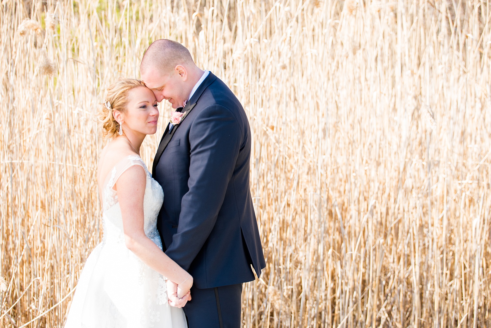 Saratoga Springs destination wedding photos by Mikkel Paige Photography. The bride and groom share a moment on the venue's property at Saratoga National Golf Club among the tall grasses for their spring, April wedding. #SaratogaSpringsNY #SaratogaSprings #mikkelpaige #NYwedding #destinationwedding 