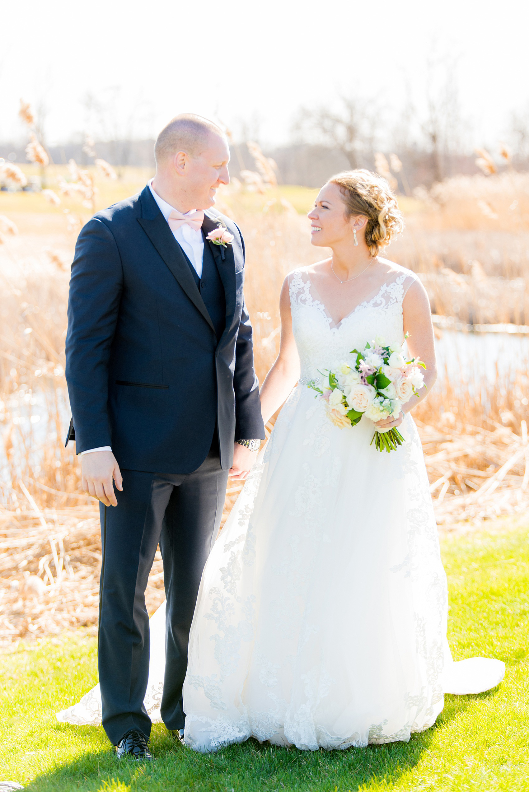 Saratoga Springs destination wedding photos by Mikkel Paige Photography. The bride and groom share a moment on the venue's green lawn surrounded by spring greenery for their reception held at Saratoga National Golf Club. #SaratogaSpringsNY #SaratogaSprings #mikkelpaige #NYwedding #destinationwedding 