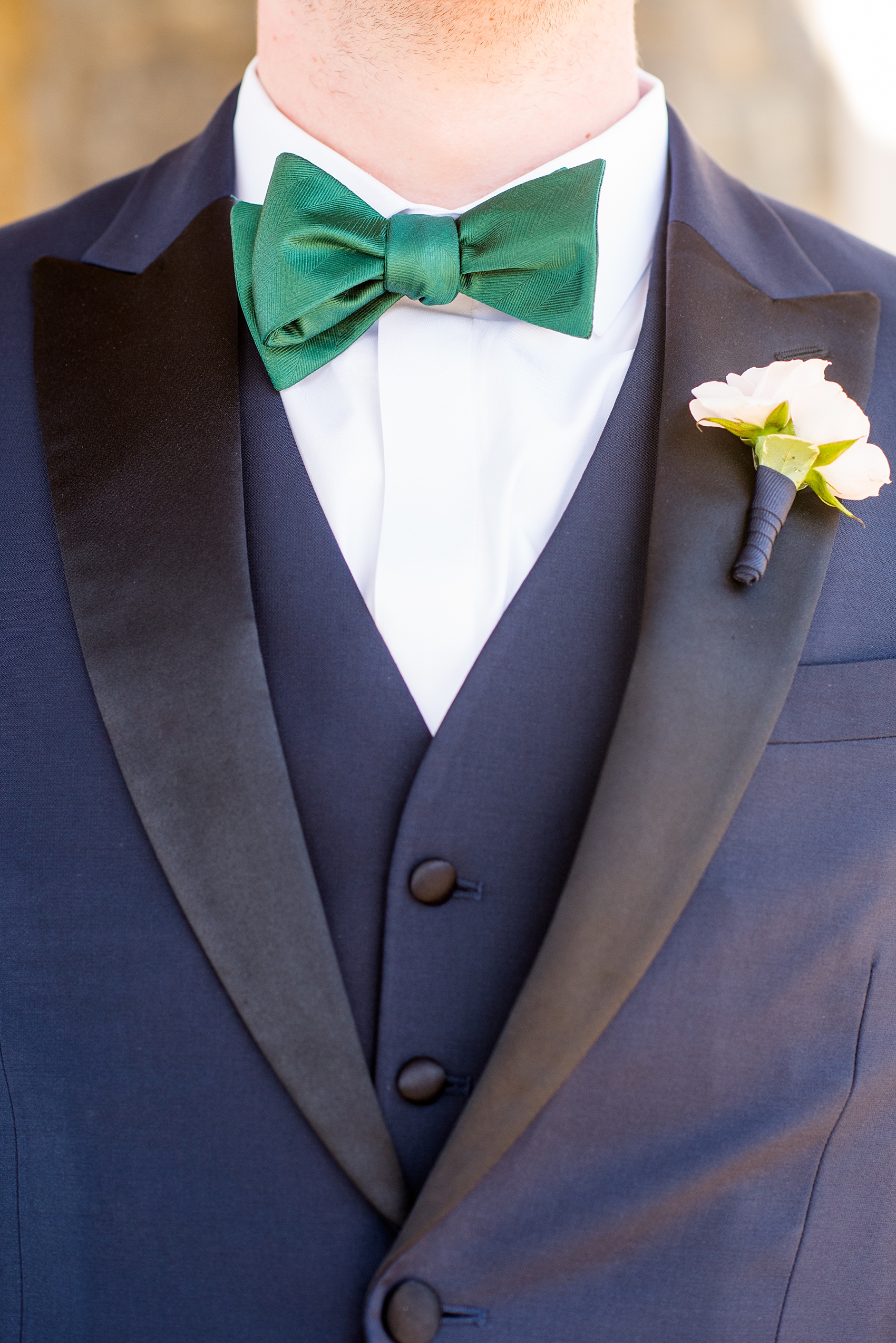 Saratoga Springs destination wedding photos by Mikkel Paige Photography. This picture shows the groomsmen navy blue suit with black lapel, green bow tie and white spray rose boutonniere tied with navy blue ribbon. The spring event was held at Saratoga National Golf Club venue. #SaratogaSpringsNY #SaratogaSprings #mikkelpaige #NYwedding #destinationwedding 