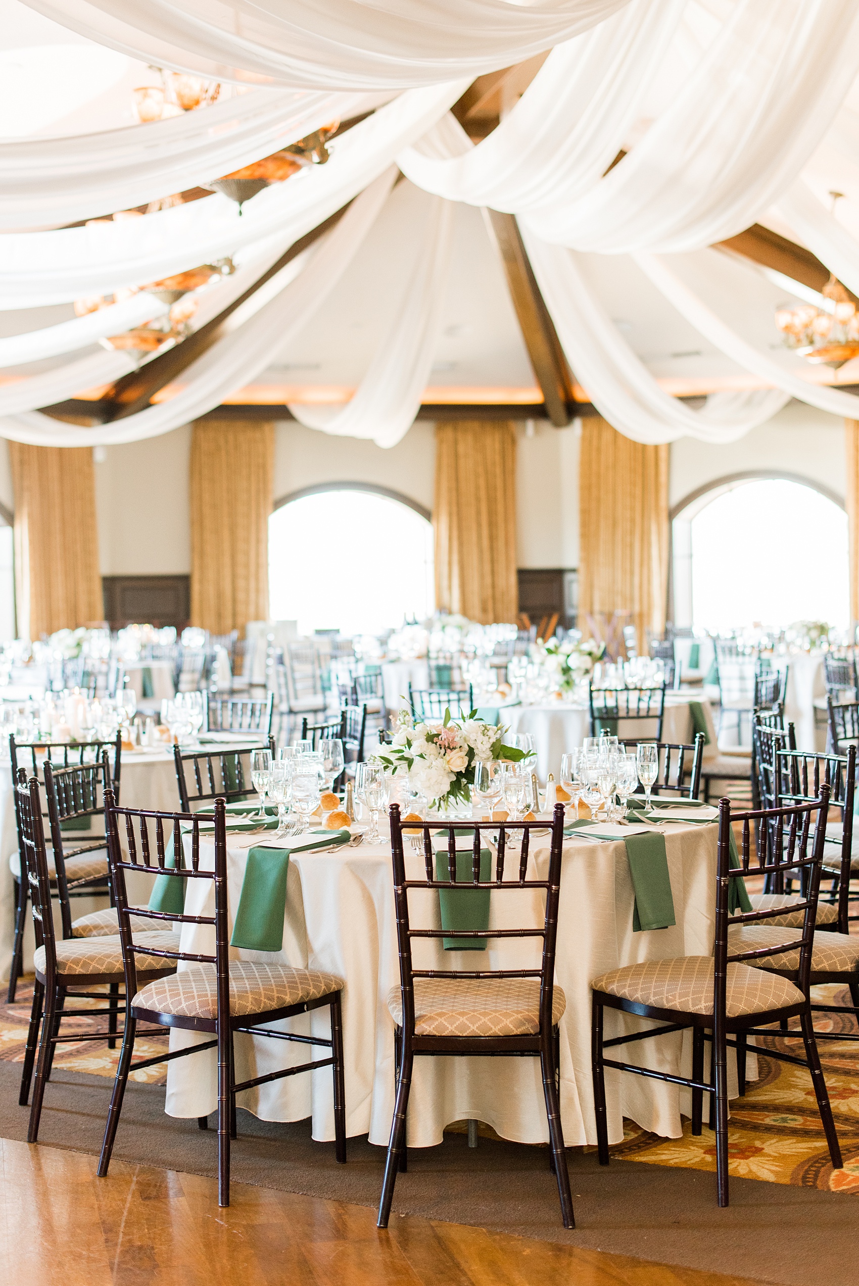 Saratoga Springs destination wedding photos by Mikkel Paige Photography. The spring event was held at Saratoga National Golf Club venue for a spring celebration. The reception room was decorated with custom white draping, and green and gold color palette elements. #SaratogaSpringsNY #SaratogaSprings #mikkelpaige #NYwedding #destinationwedding #saratogaweddingvenue #golfcoursewedding #customdraping #springwedding