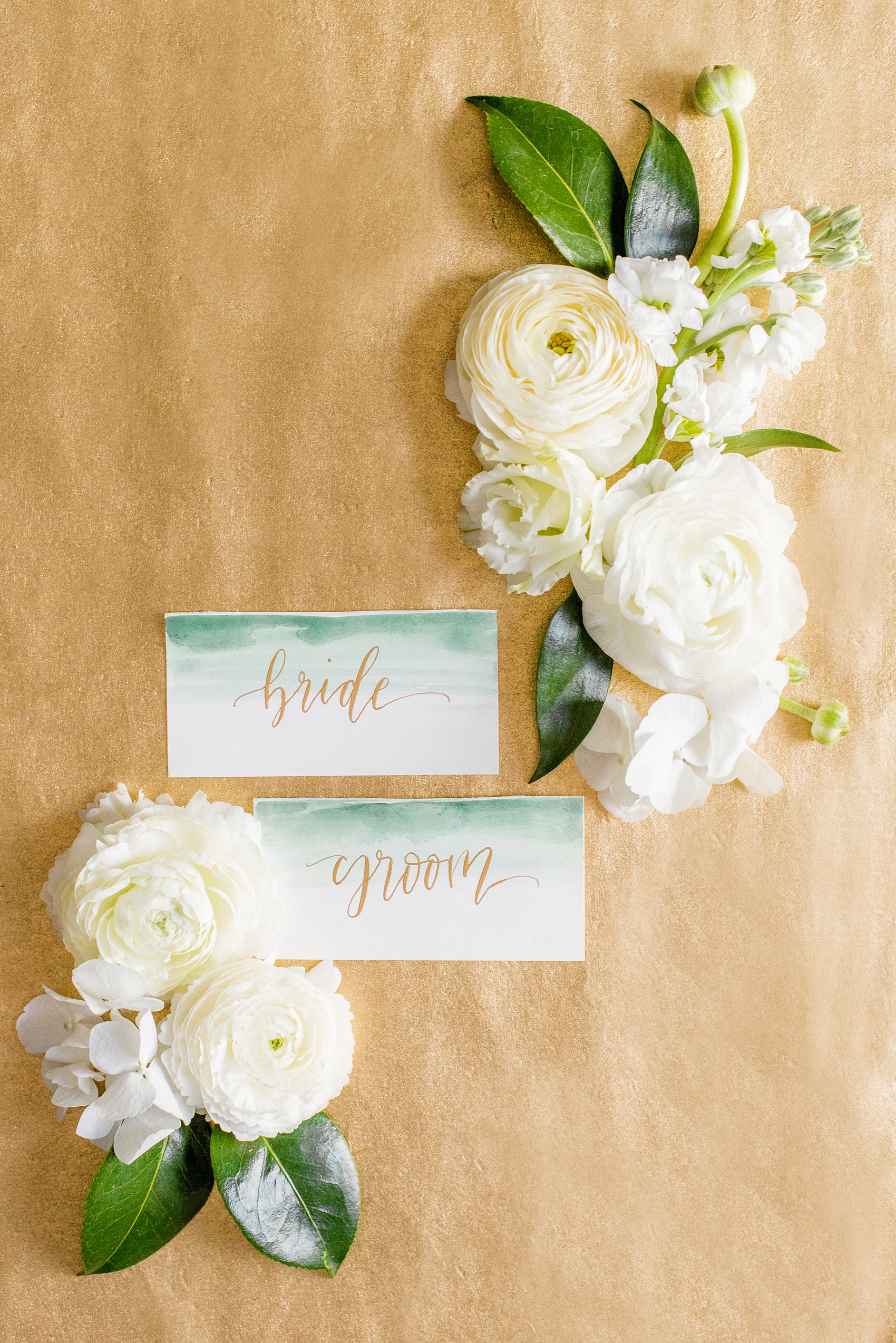 Saratoga Springs destination wedding photos by Mikkel Paige Photography. The event was held at Saratoga National Golf Club venue for a spring celebration. The escort cards stuck with the gold and green color palette, and had a brush of watercolor at the top with gold calligraphy. #SaratogaSpringsNY #SaratogaSprings #mikkelpaige #NYwedding #destinationwedding #saratogaweddingvenue #golfcoursewedding #customdraping #springwedding
