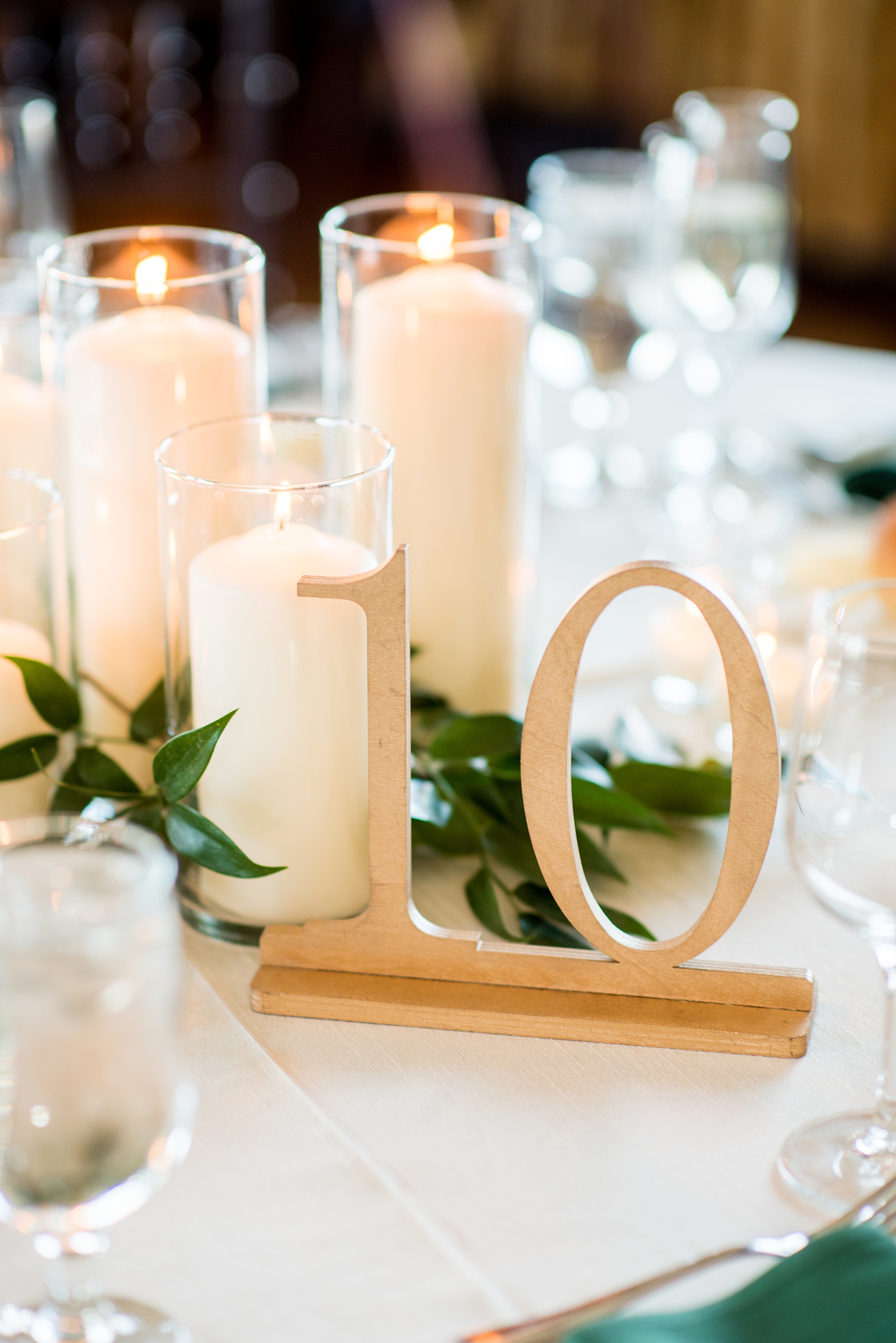 Saratoga Springs destination wedding photos by Mikkel Paige Photography. The spring event was held at Saratoga National Golf Club venue. The reception room was decorated with custom draping, and green and gold color palette elements including candlelight and wooden gold table numbers. #SaratogaSpringsNY #SaratogaSprings #mikkelpaige #NYwedding #destinationwedding #saratogaweddingvenue #golfcoursewedding #customdraping #springwedding