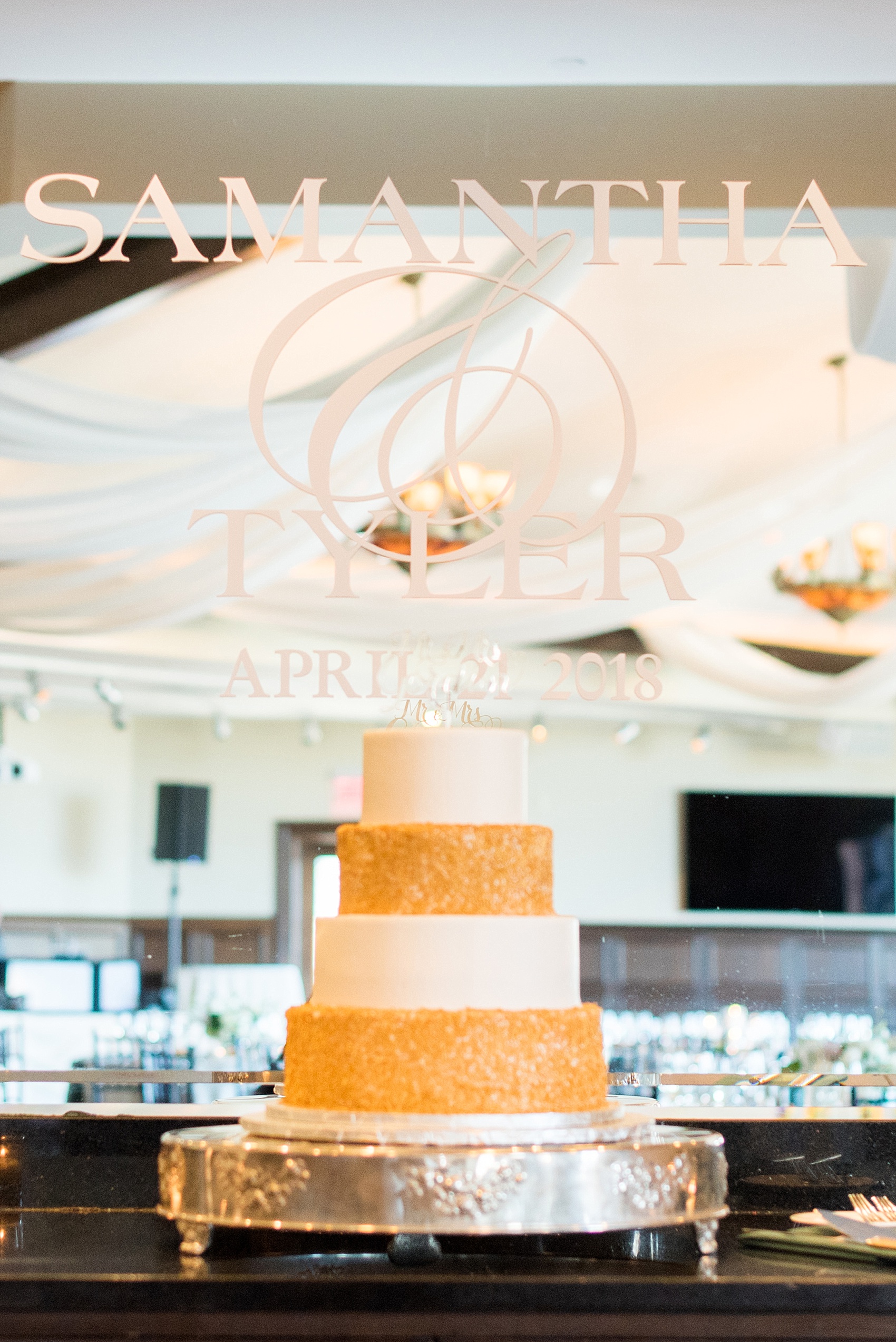 Saratoga Springs destination wedding photos by Mikkel Paige Photography. The gold and white cake was covered in gold sprinkles and white fondant, with a custom script gold acrylic cake topper. The spring reception was held at Saratoga National Golf Club venue. #SaratogaSpringsNY #SaratogaSprings #mikkelpaige #NYwedding #destinationwedding