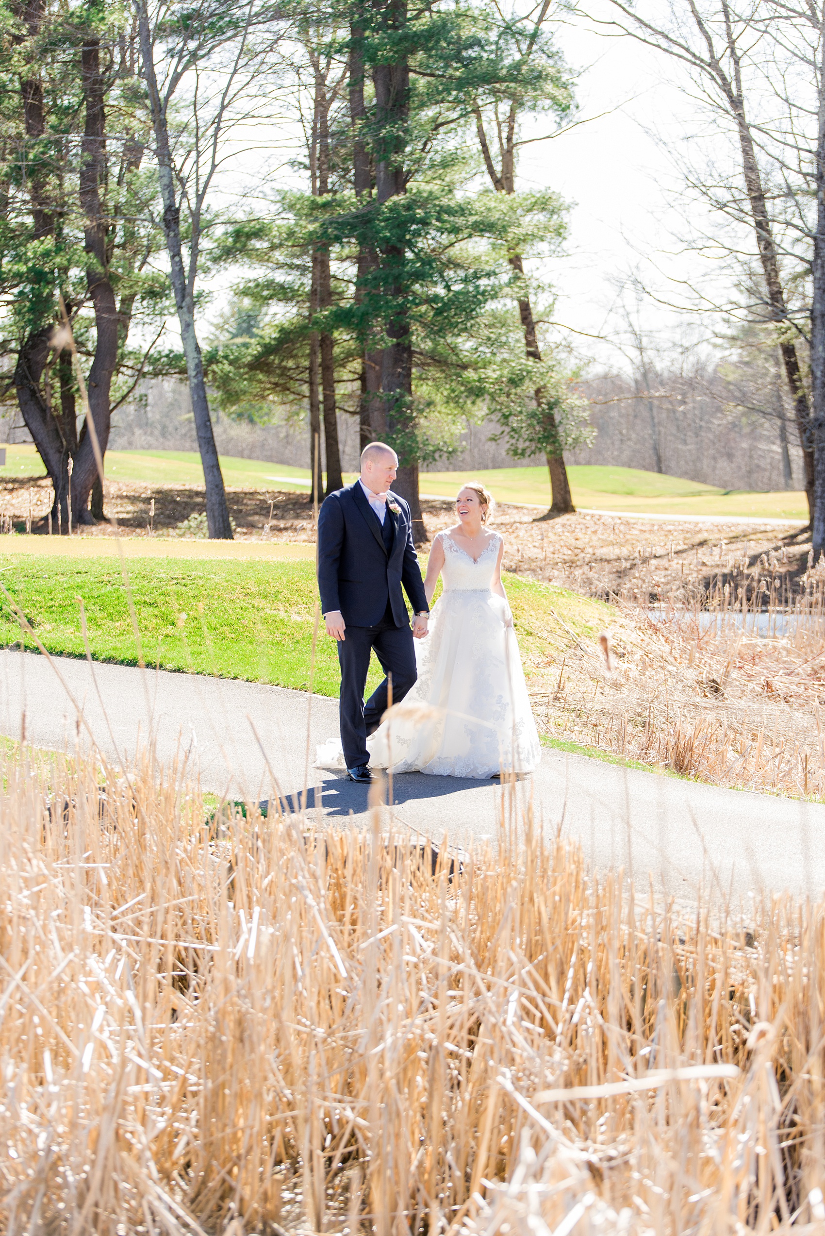 Photos from Saratoga Springs, New York by Mikkel Paige Photography. This picture shows the bride and groom walking on the golf course during their spring wedding. #SaratogaSprings #golfcoursewedding #SaratogaSpringsNY #SpringWedding 