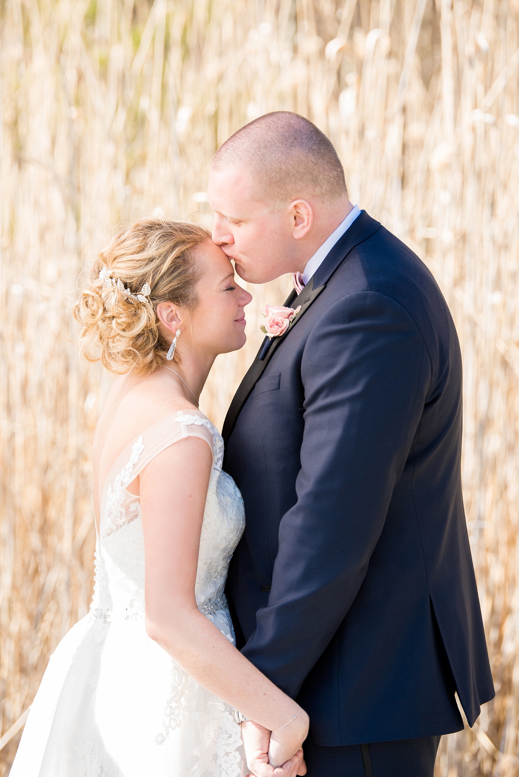 Photos from Saratoga Springs, New York by Mikkel Paige Photography. The bride and groom kiss in front of tall grasses during their spring wedding. #SaratogaSprings #golfcoursewedding #SaratogaSpringsNY #SpringWedding 