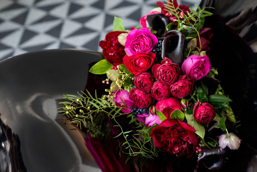 W Hoboken wedding photos by Mikkel Paige Photography at this NJ venue. Pictures in this well known New Jersey city with a view of the NYC skyline. This detail image is of the semi-cascading bouquet includes red, fuchsia and burgundy peonies, calla lilies, Japanese roses, helebores dahlias and ranunculus by Sachi Rose Design. #mikkelpaige #HobokenWedding #NewJerseyPhotographer #NewYorkCityPhotographer #NYCweddingphotographer #brideandgroomphotos #redpeonies #romanticwedding #springwedding #CityWedding