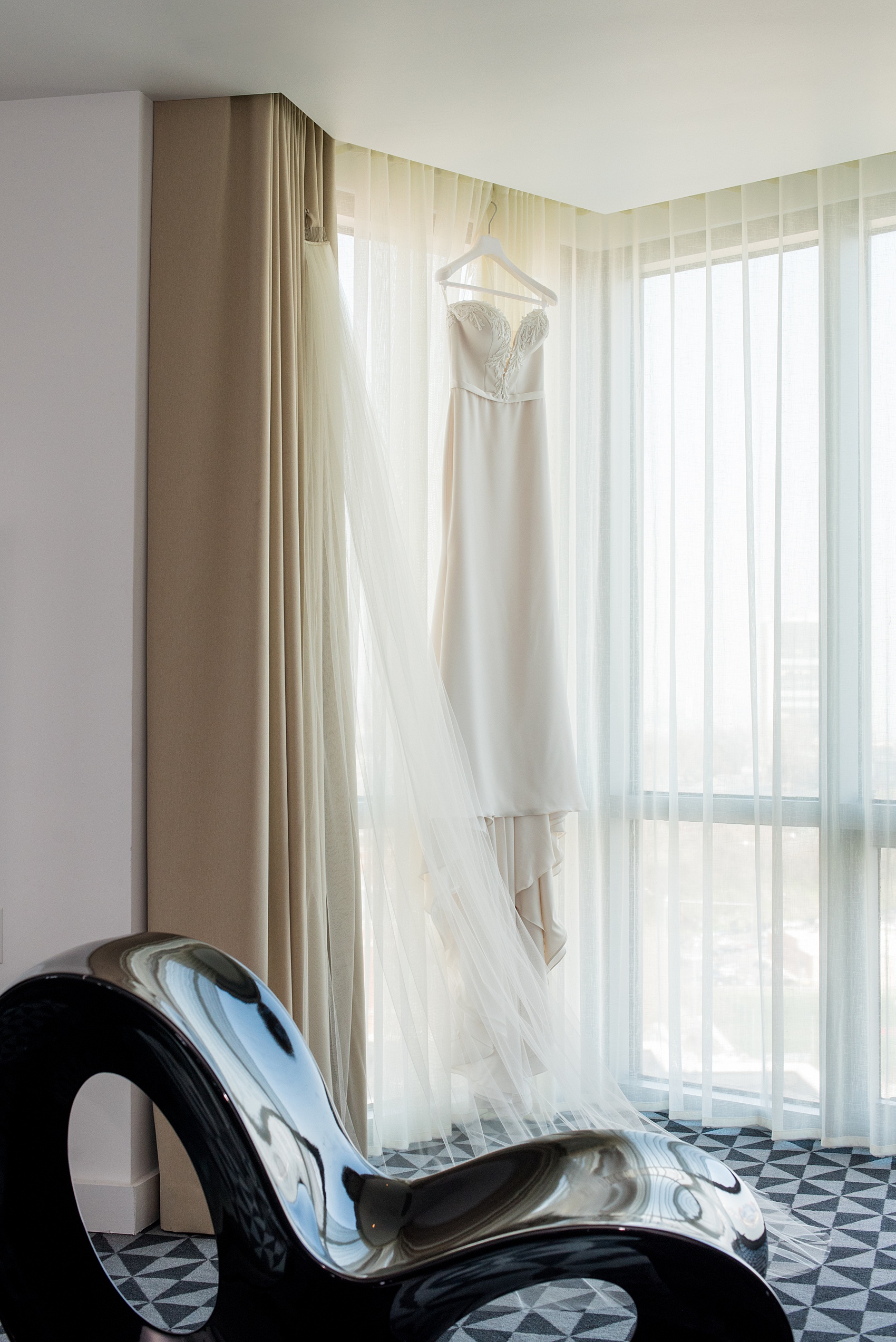 W Hoboken wedding photos by Mikkel Paige Photography. Detail picture of the bride's off-white, strapless Paloma Blanca gown inside the venue hotel room during getting ready. #mikkelpaige #HobokenWedding #NewJerseyPhotographer #NewYorkCityPhotographer #NYCweddingphotographer #brideandgroomphotos #redpeonies #romanticwedding #springwedding #CityWedding