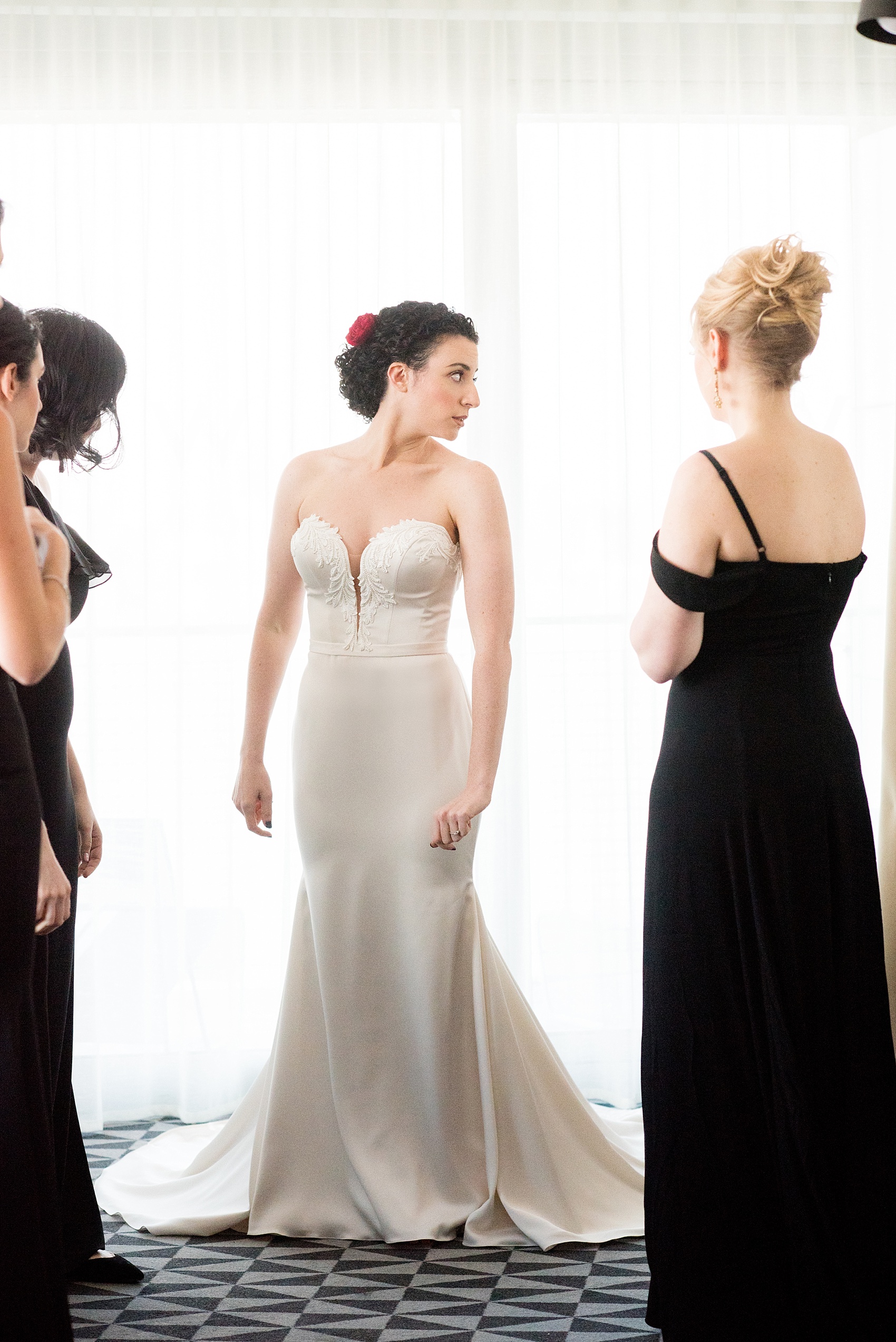 W Hoboken wedding photos by Mikkel Paige Photography. Picture of the bride getting into her Paloma Blanca, strapless pearl beaded wedding gown with her bridesmaids. #mikkelpaige #HobokenWedding #NewJerseyPhotographer #NewYorkCityPhotographer #NYCweddingphotographer #brideandgroomphotos #redpeonies #romanticwedding #springwedding #CityWedding