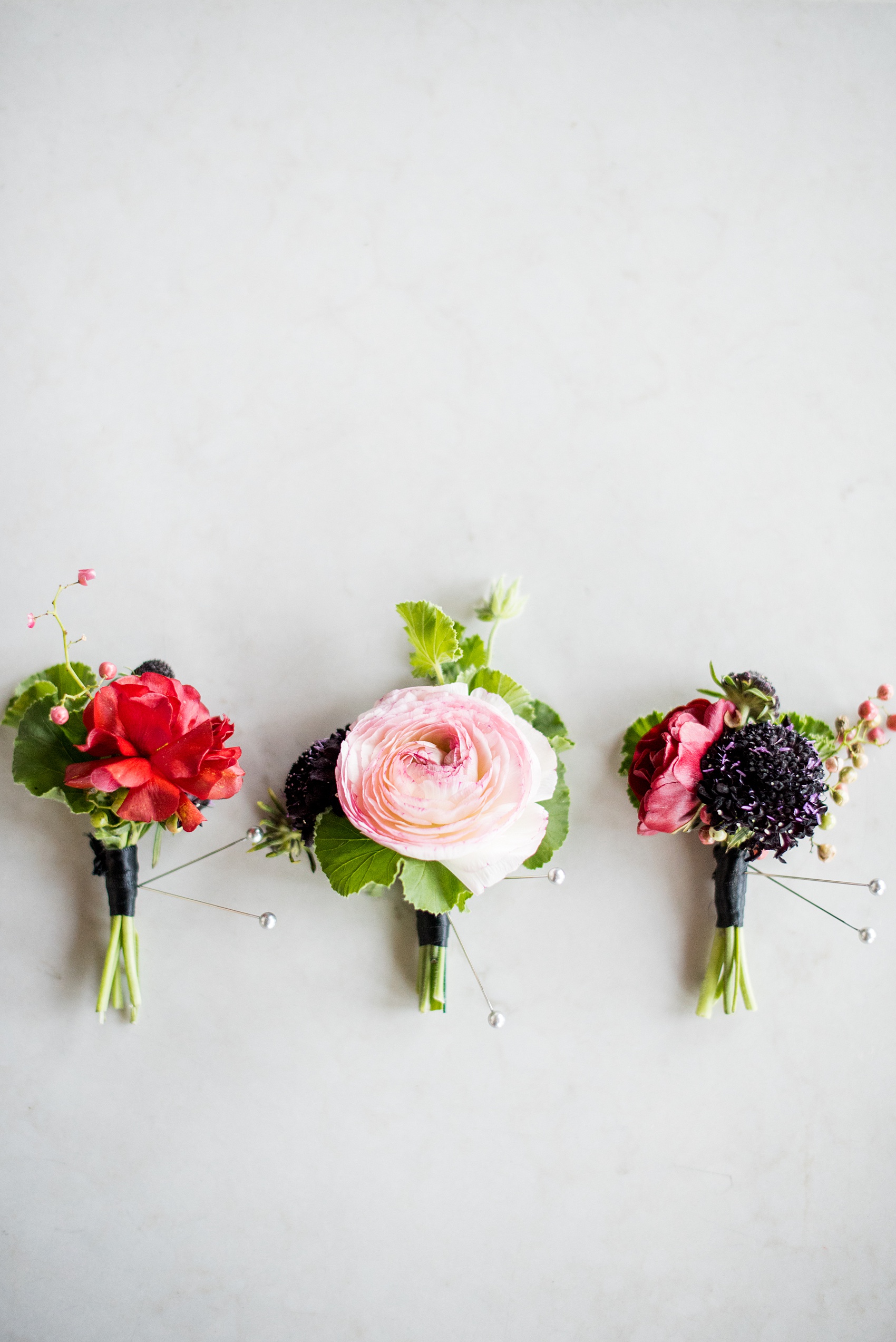 W Hoboken wedding photos by Mikkel Paige Photography. Picture of the varied boutonnieres for the groom and groomsmen by Sachi Rose Designs, including ranunculus, geranium leaves and cosmos. #mikkelpaige #HobokenWedding #NewJerseyPhotographer #NewYorkCityPhotographer #NYCweddingphotographer #brideandgroomphotos #redpeonies #romanticwedding #springwedding #CityWedding