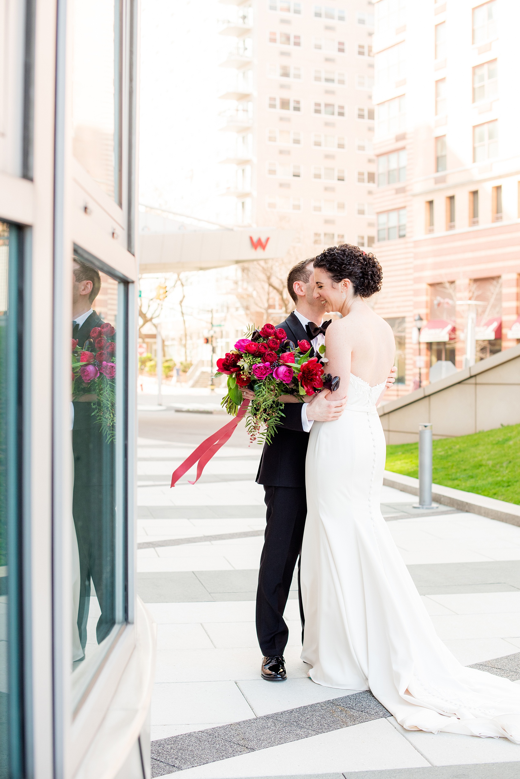 W Hoboken wedding photos by Mikkel Paige Photography. Pictures in this well known New Jersey area with a view of the Manhattan skyline. The groom and bride shared their first look outside of the venue. #mikkelpaige #HobokenWedding #NewJerseyPhotographer #NewYorkCityPhotographer #NYCweddingphotographer #brideandgroomphotos #redpeonies #romanticwedding #springwedding #CityWedding