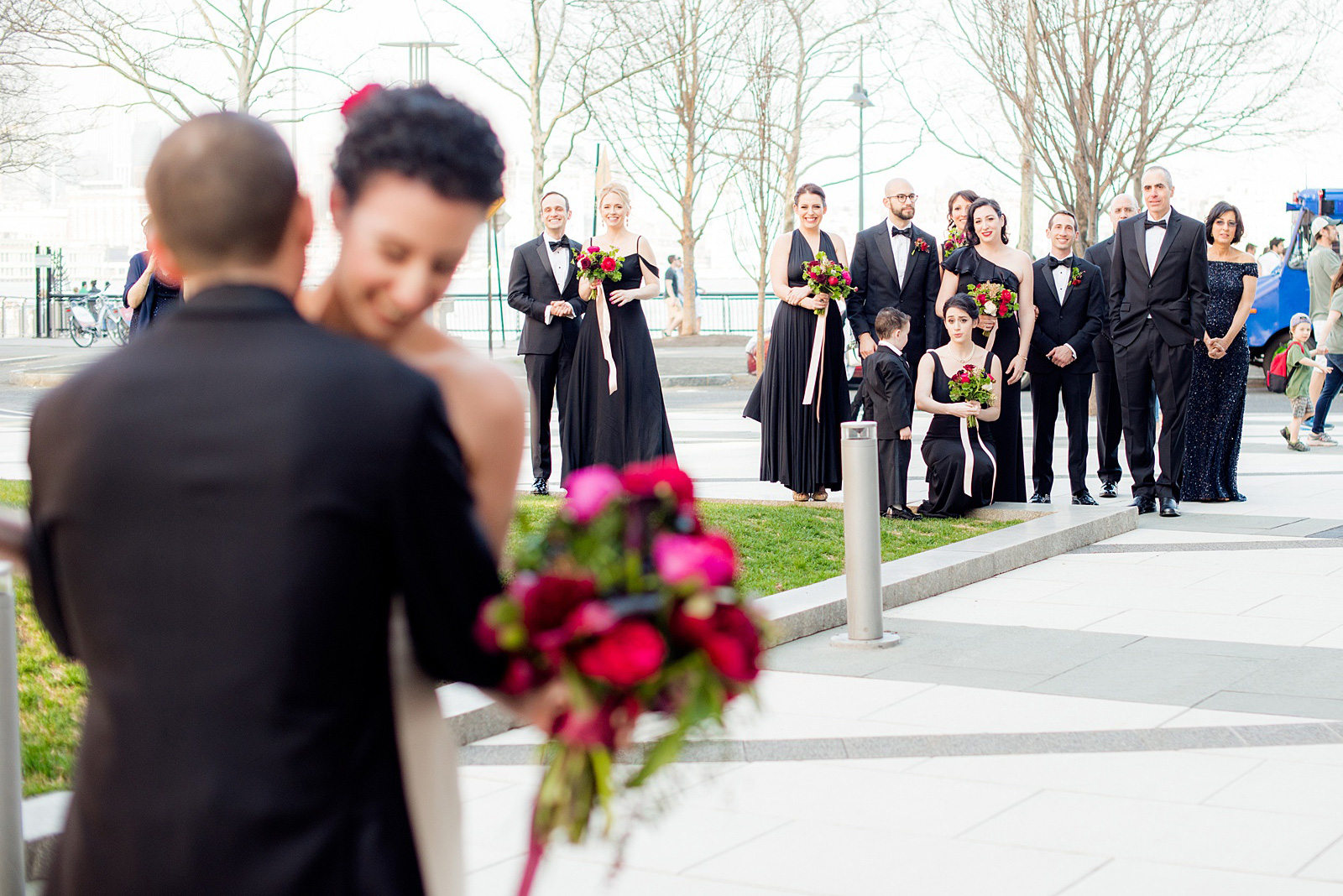 W Hoboken wedding photos by Mikkel Paige Photography at this NJ venue. Pictures in this well known New Jersey city with a view of the NYC skyline. The bride and the groom wore romantic colors including burgundy, fuchsia, red and classic black. Flowers by Sachi Rose Design. The bridal party watched the first look from a distance. #mikkelpaige #HobokenWedding #NewJerseyPhotographer #NewYorkCityPhotographer #NYCweddingphotographer #brideandgroomphotos #redpeonies #romanticwedding #springwedding #CityWedding