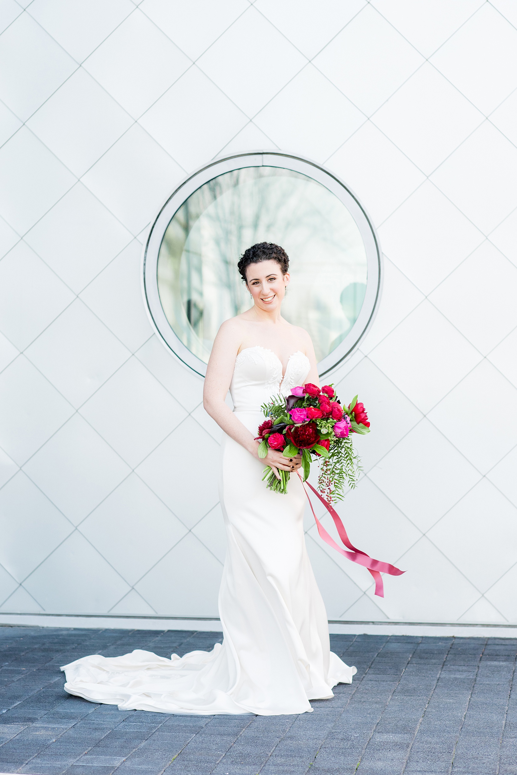 W Hoboken wedding photos by Mikkel Paige Photography. Picture of the bride in her strapless Paloma Blanca gown in this well known New Jersey city with a view of the NYC skyline across the Hudson River. #mikkelpaige #HobokenWedding #NewJerseyPhotographer #NewYorkCityPhotographer #NYCweddingphotographer #brideandgroomphotos #redpeonies #romanticwedding #springwedding #CityWedding