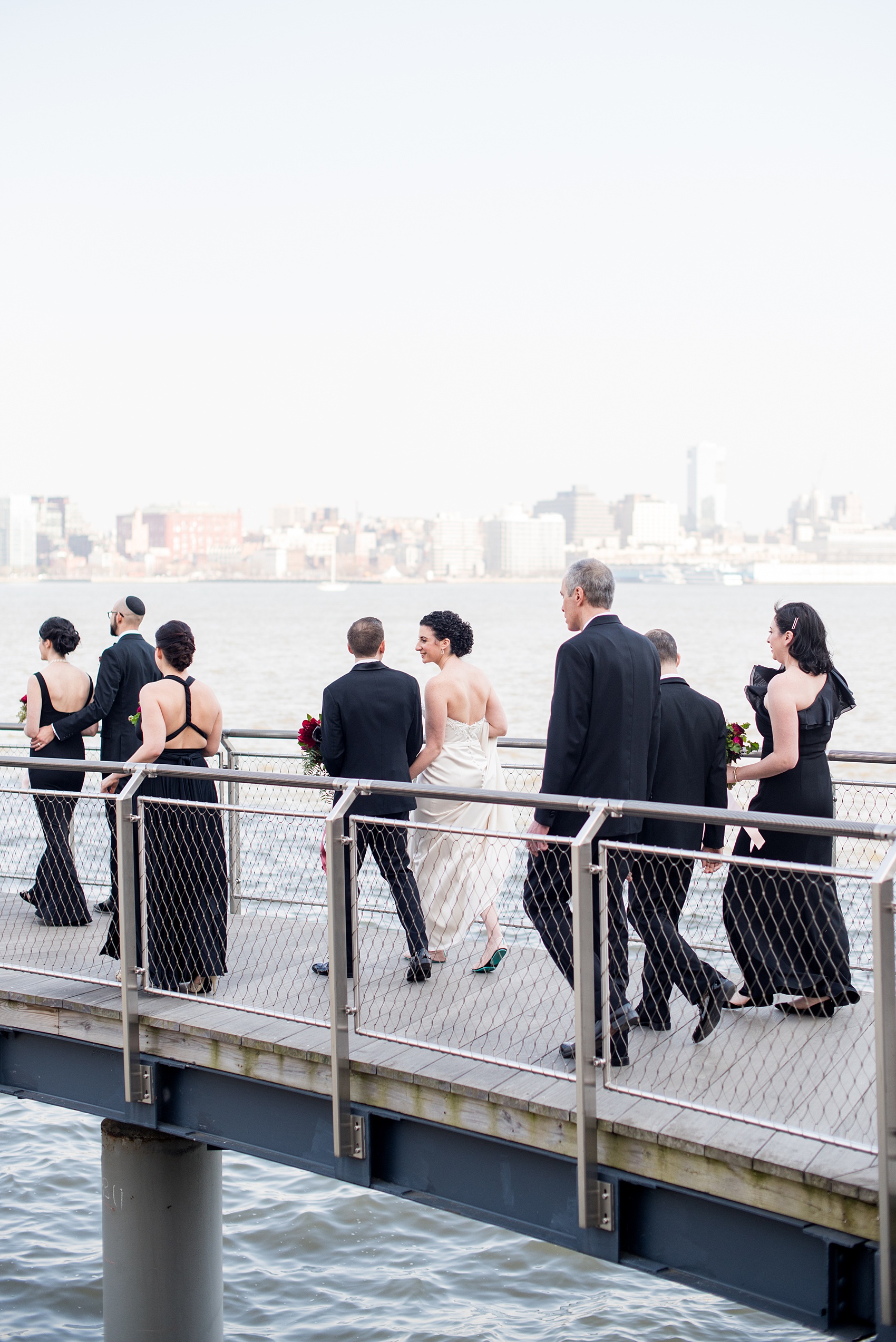 W Hoboken wedding photos by Mikkel Paige Photography. Picture of the wedding party in the park of this New Jersey venue, with the Hudson River and NYC skyline in the background. #mikkelpaige #HobokenWedding #NewJerseyPhotographer #NewYorkCityPhotographer #NYCweddingphotographer #brideandgroomphotos #redpeonies #romanticwedding #springwedding #CityWedding